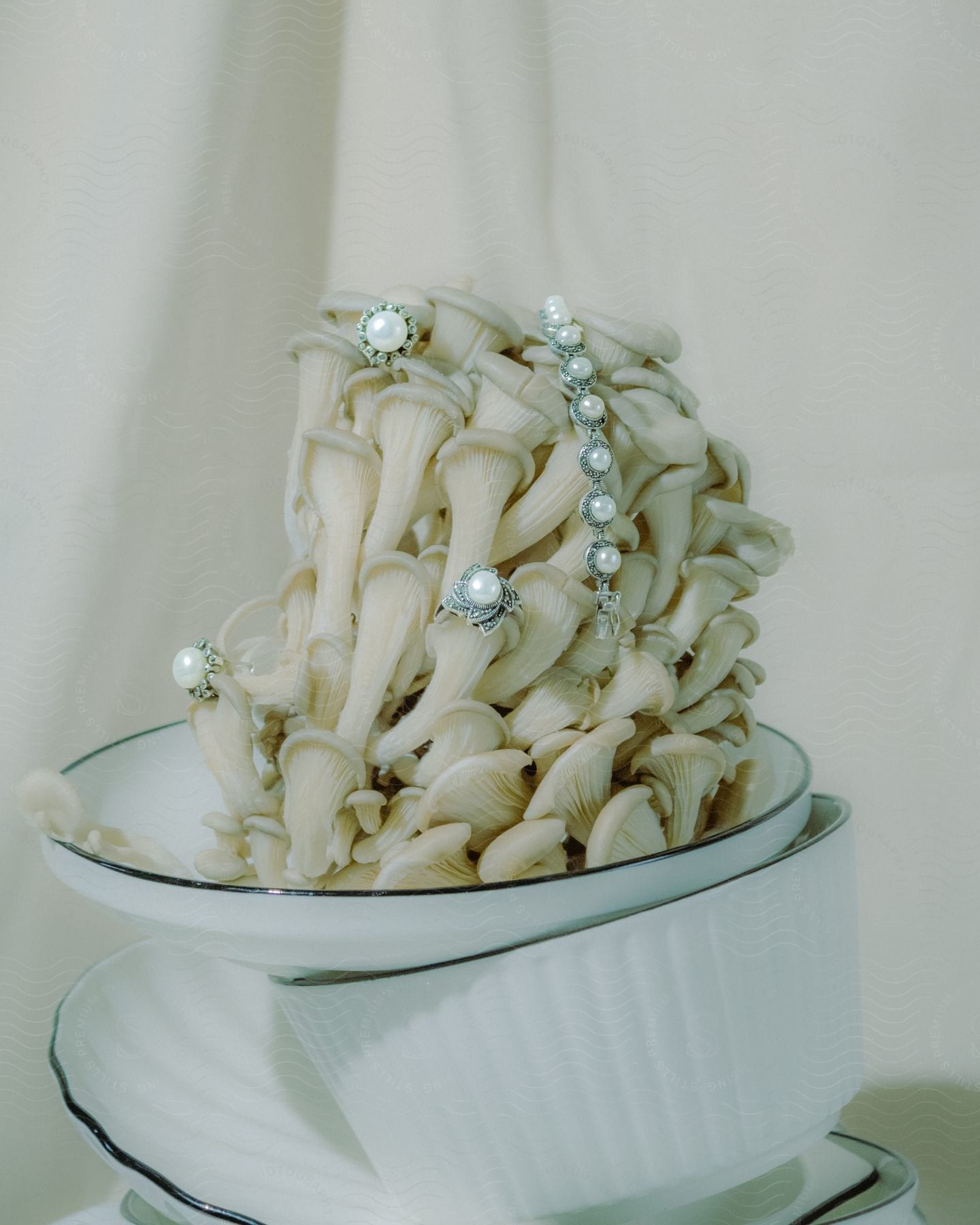 A cluster of oyster mushrooms adorned with pearl jewelry in a white bowl
