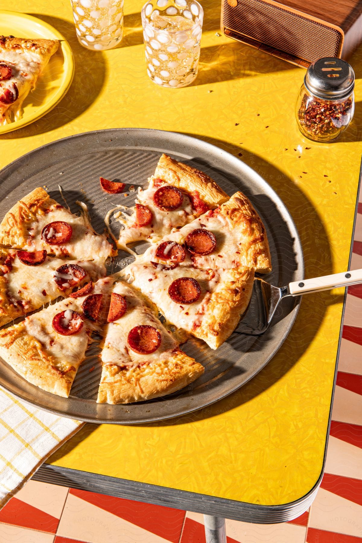 Yellow table with pizza slices and glasses