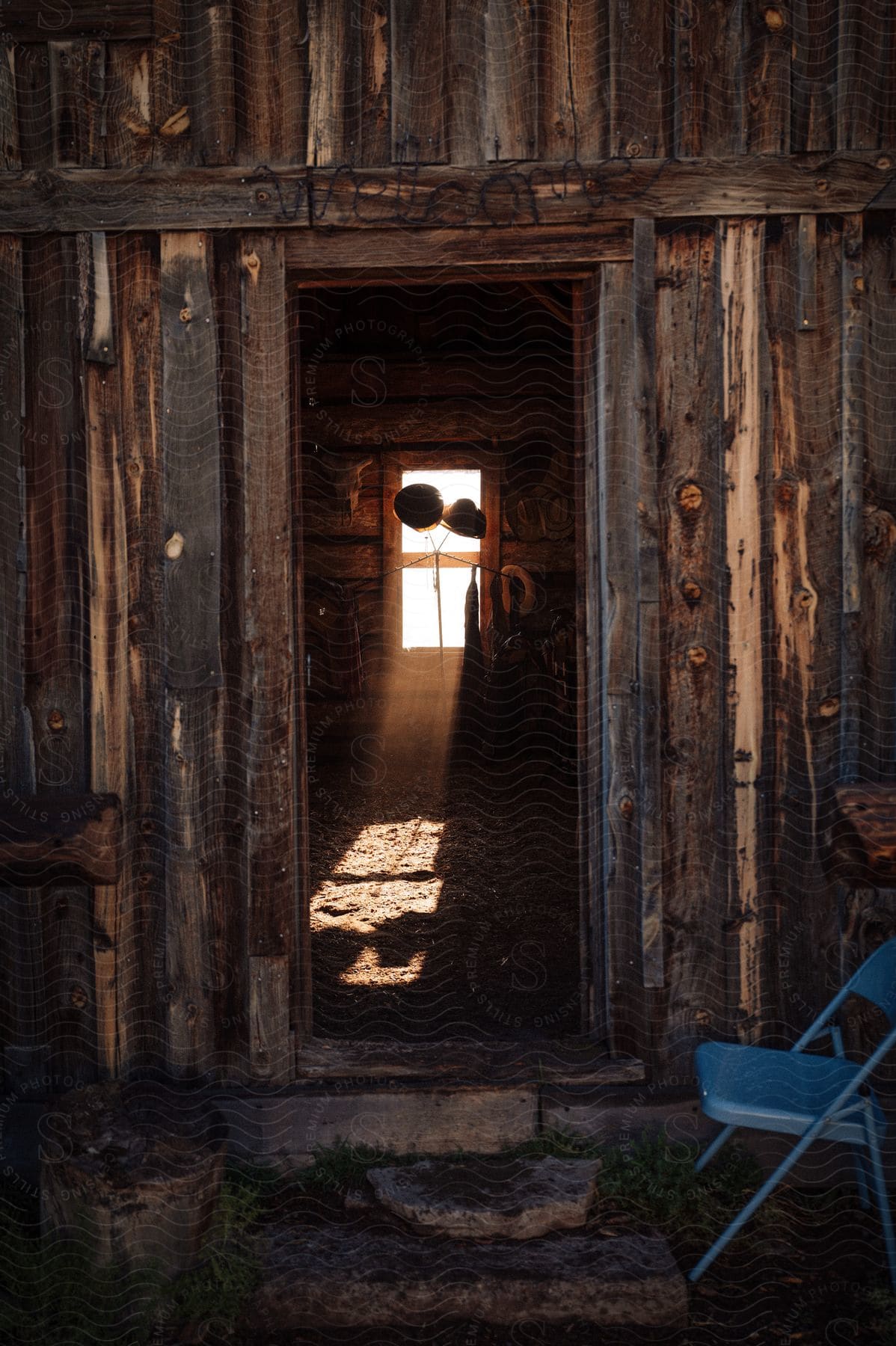 Stock photo of wooden barn with the door open and the reflection of sunlight coming through the window.