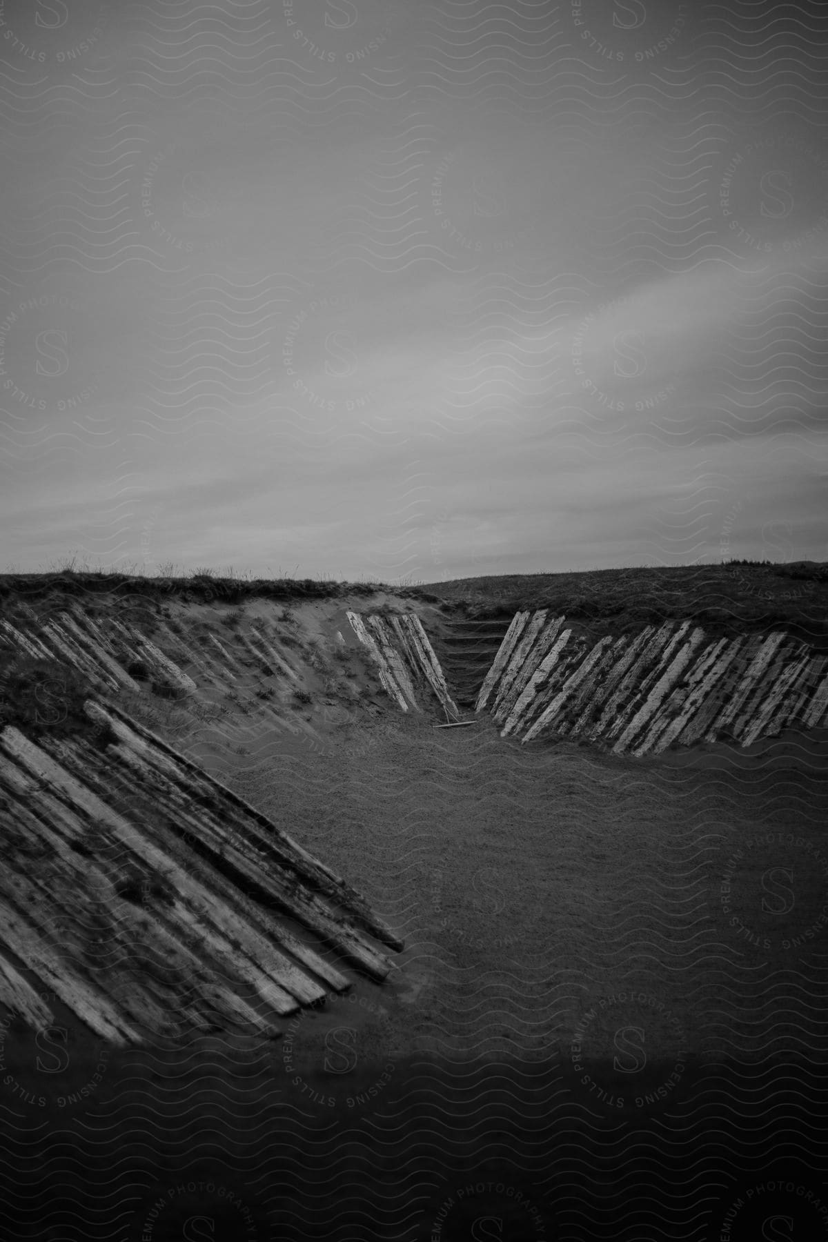 A barren landscape with wooden barriers embedded in the ground