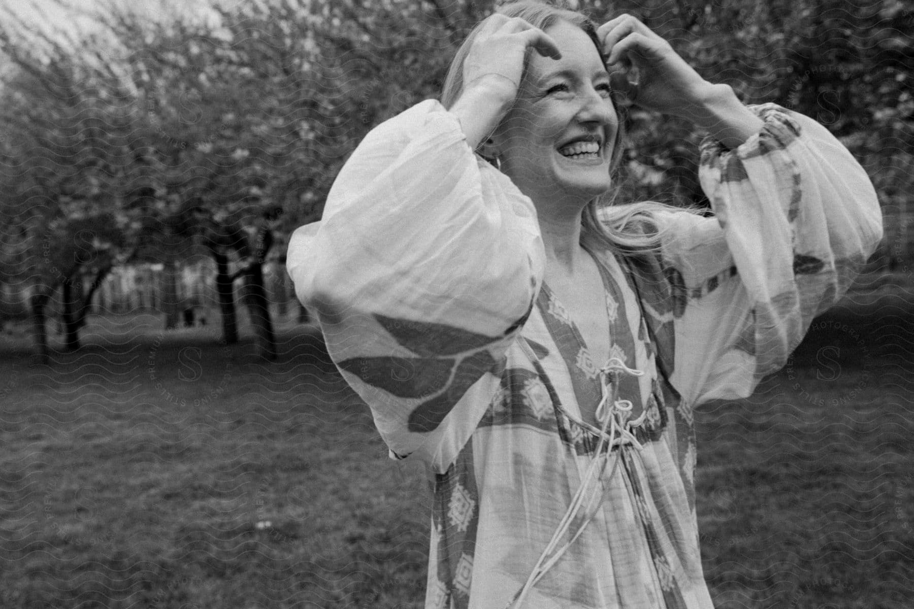 A woman standing outdoors in an area with trees