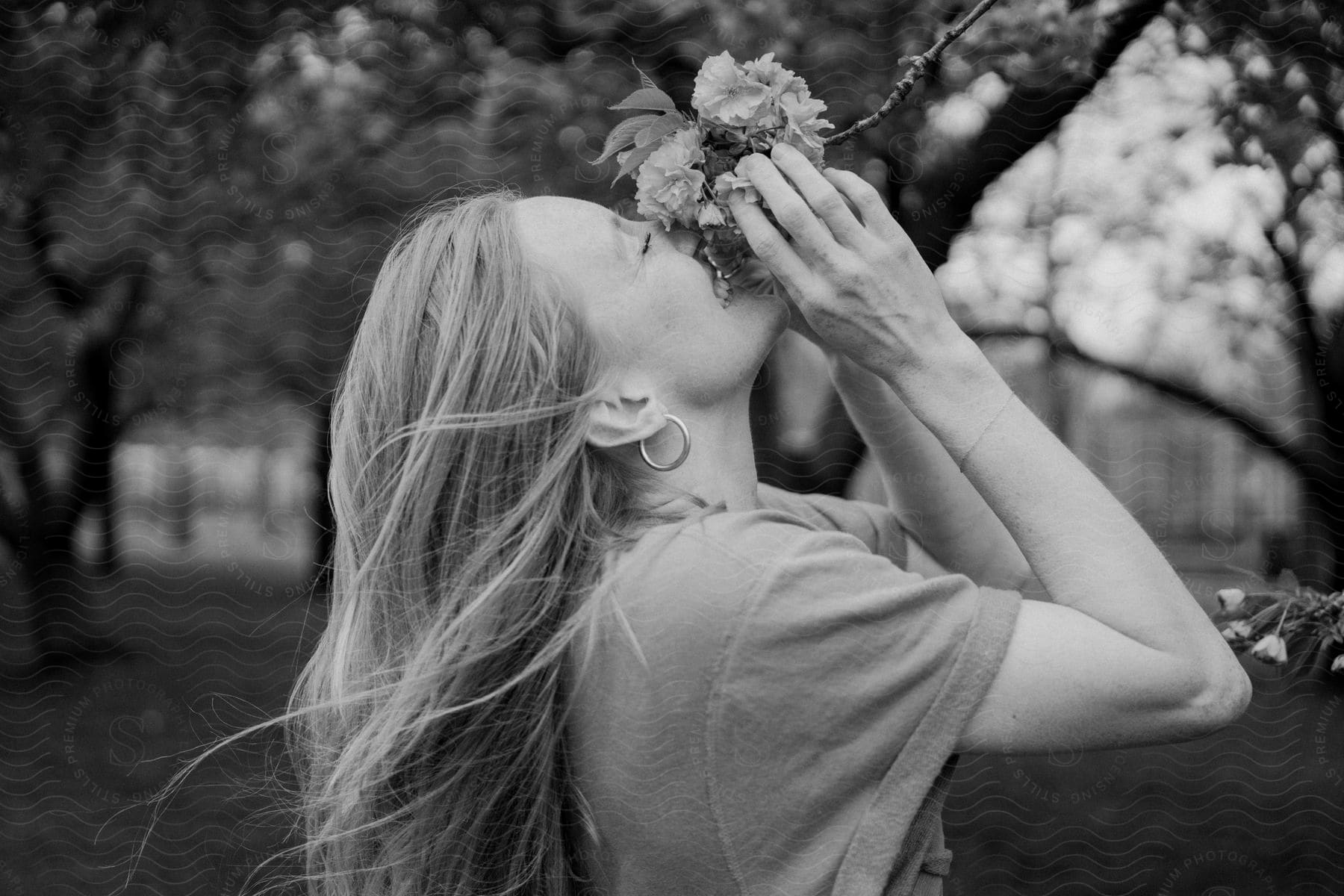 A person is smelling flowers in the park.