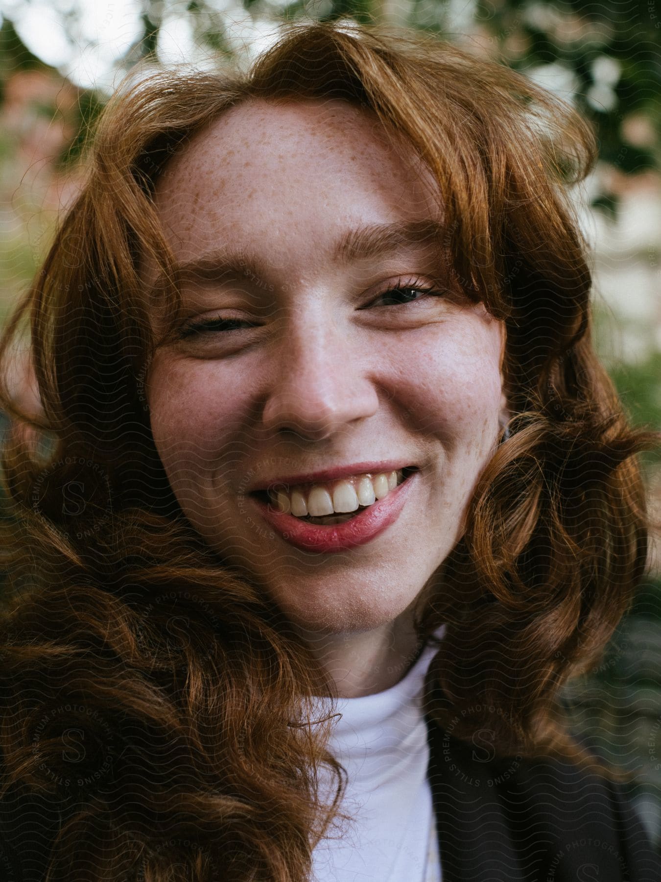 Close up of a young woman's face as she smiles and laughs