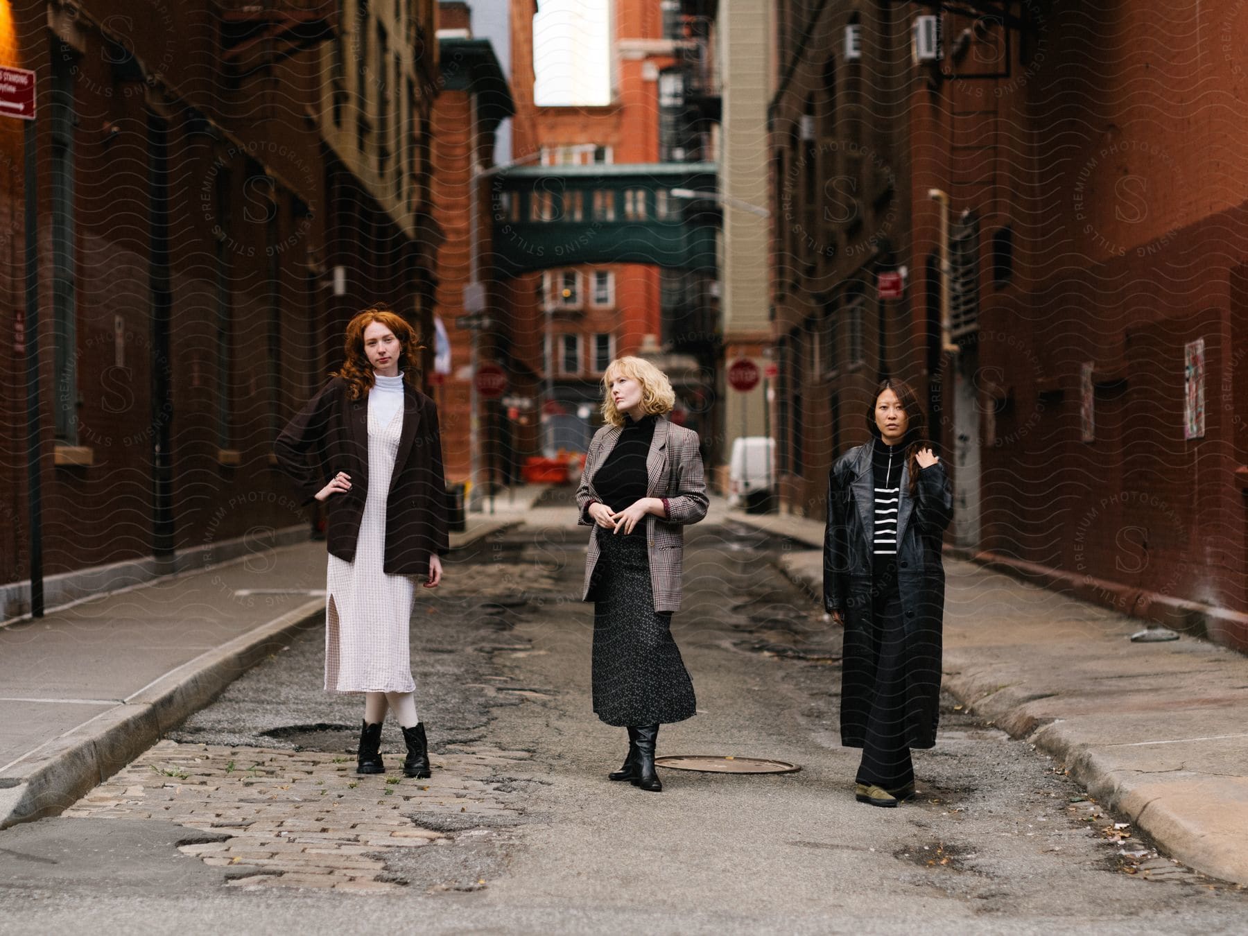 Three woman standing in alley between apartment buildings