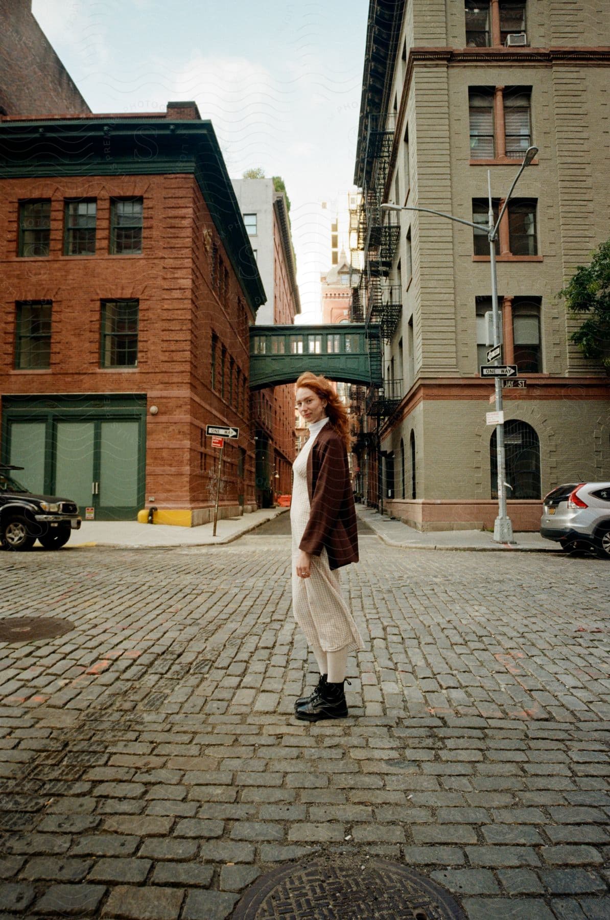 A person walks down a cobbled street, surrounded by old buildings.