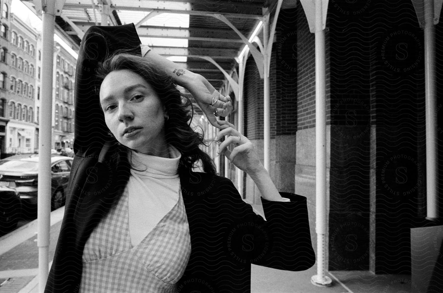 A woman poses on a downtown street in an urban city landscape