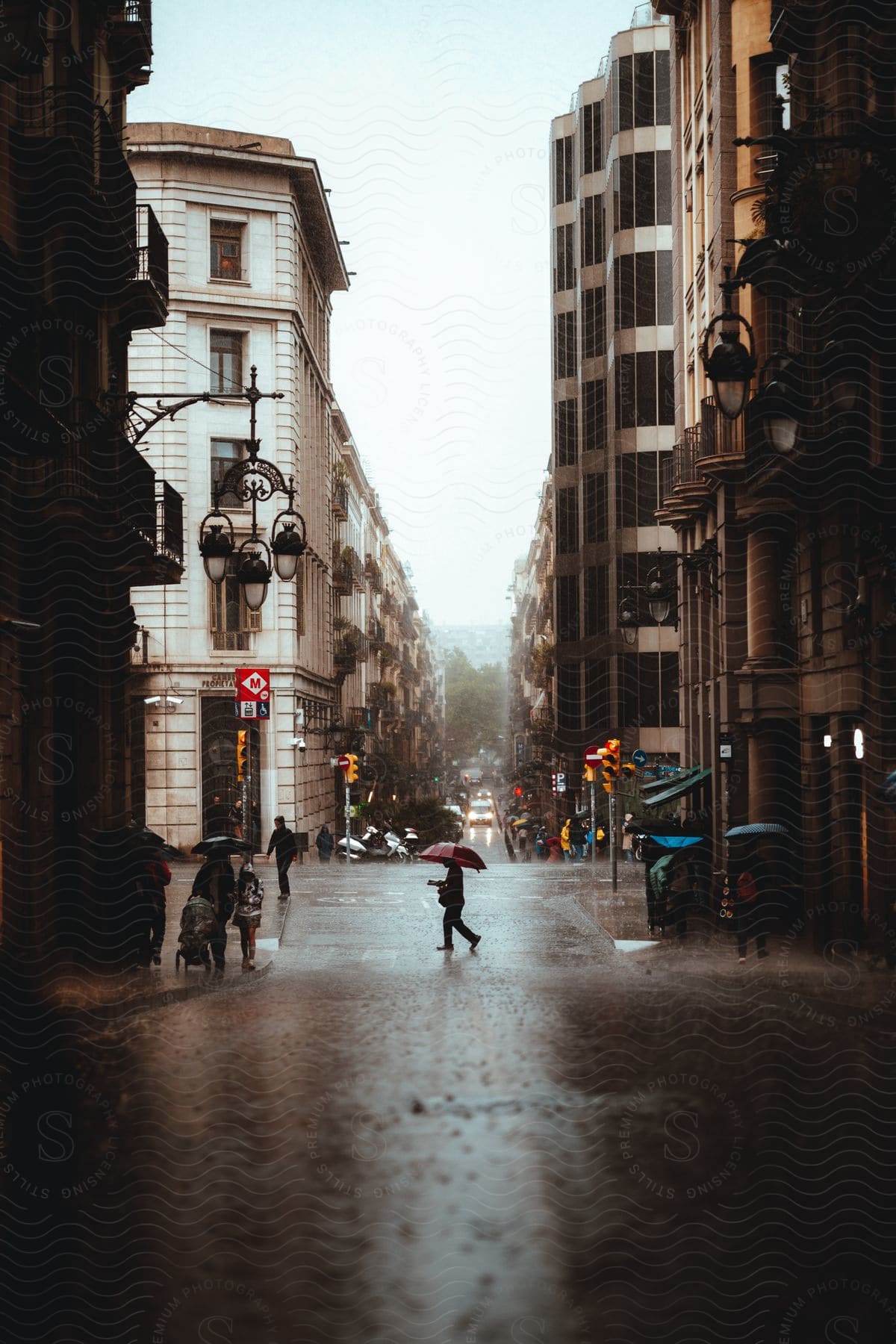 Pedestrian carrying an umbrella crossing a downtown street in the rain as traffic moves in the distance