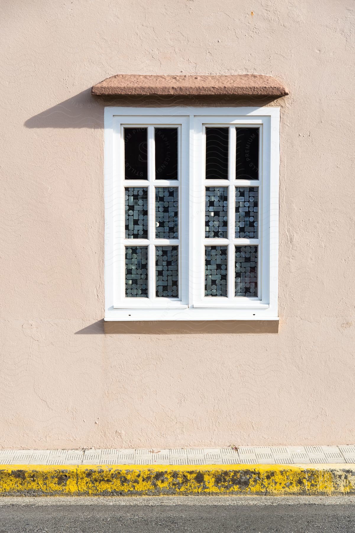 A rural window decorated with small circles and rectangles