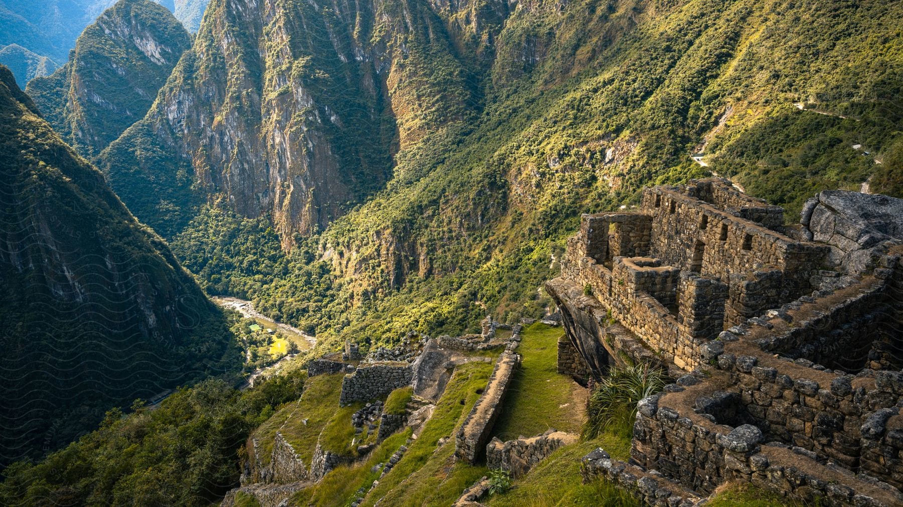 Ancient Inca city of Machu Picchu situated in the high Andes mountains with stone structures and agricultural terraces in the mountains.