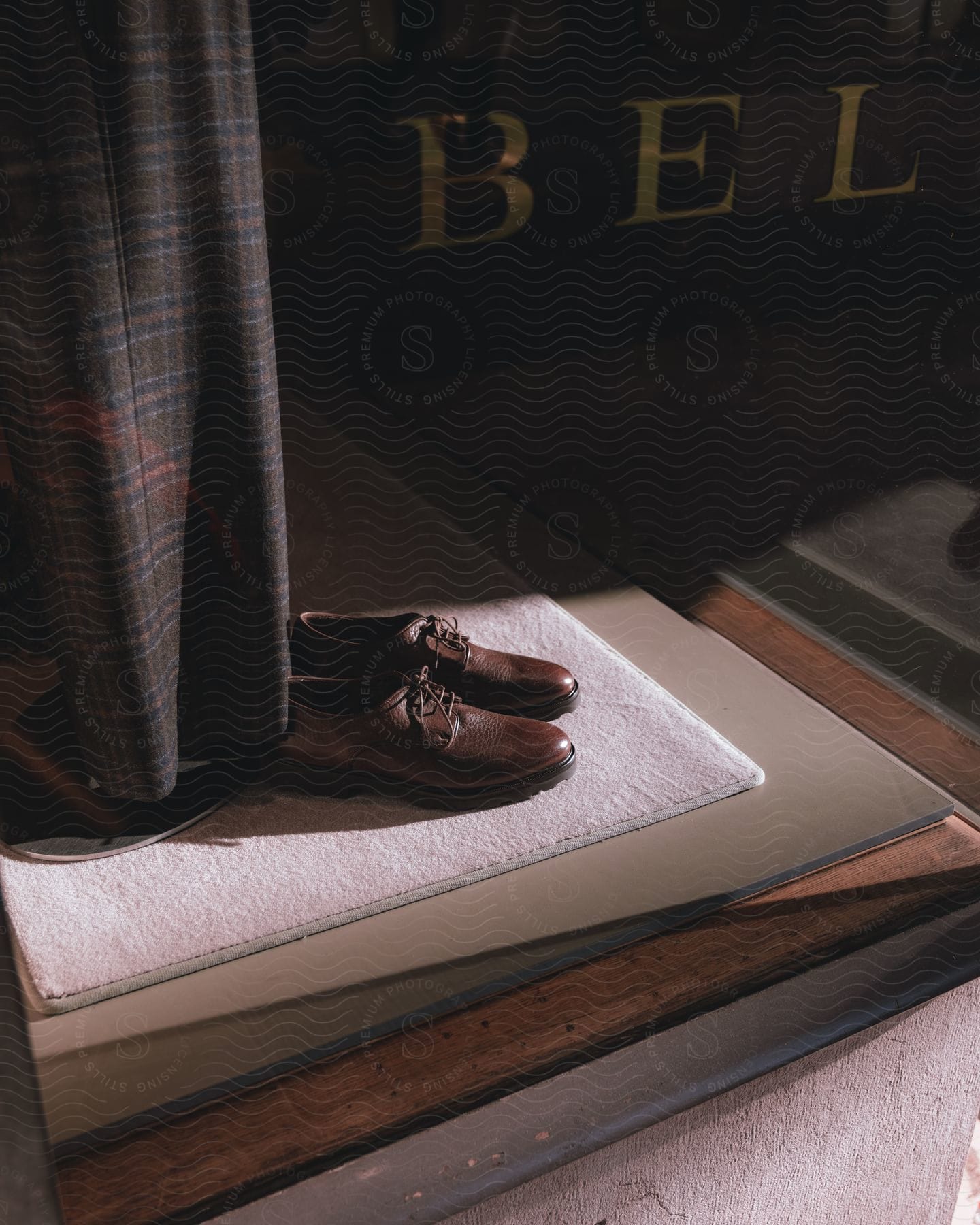 Pair of brown leather men's shoes positioned on a white surface.