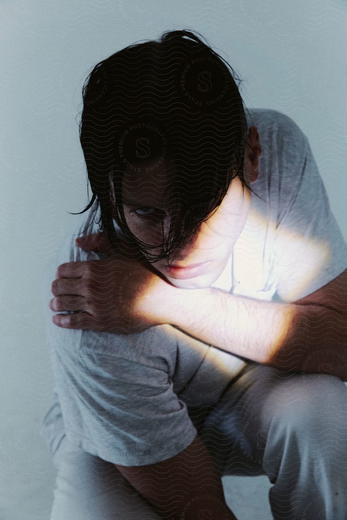 A young male with black hair posed in a crouched position, looking intense