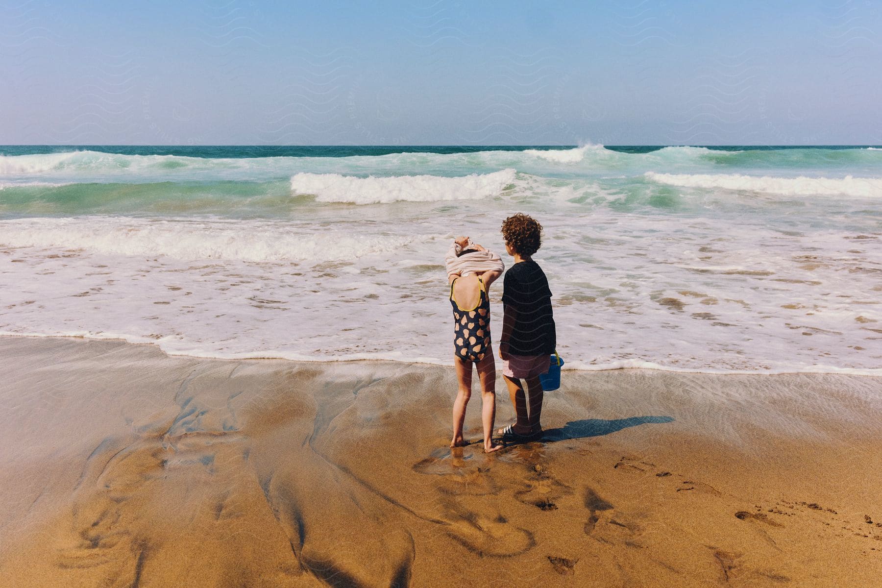 Two children standing outdoors on a the beach