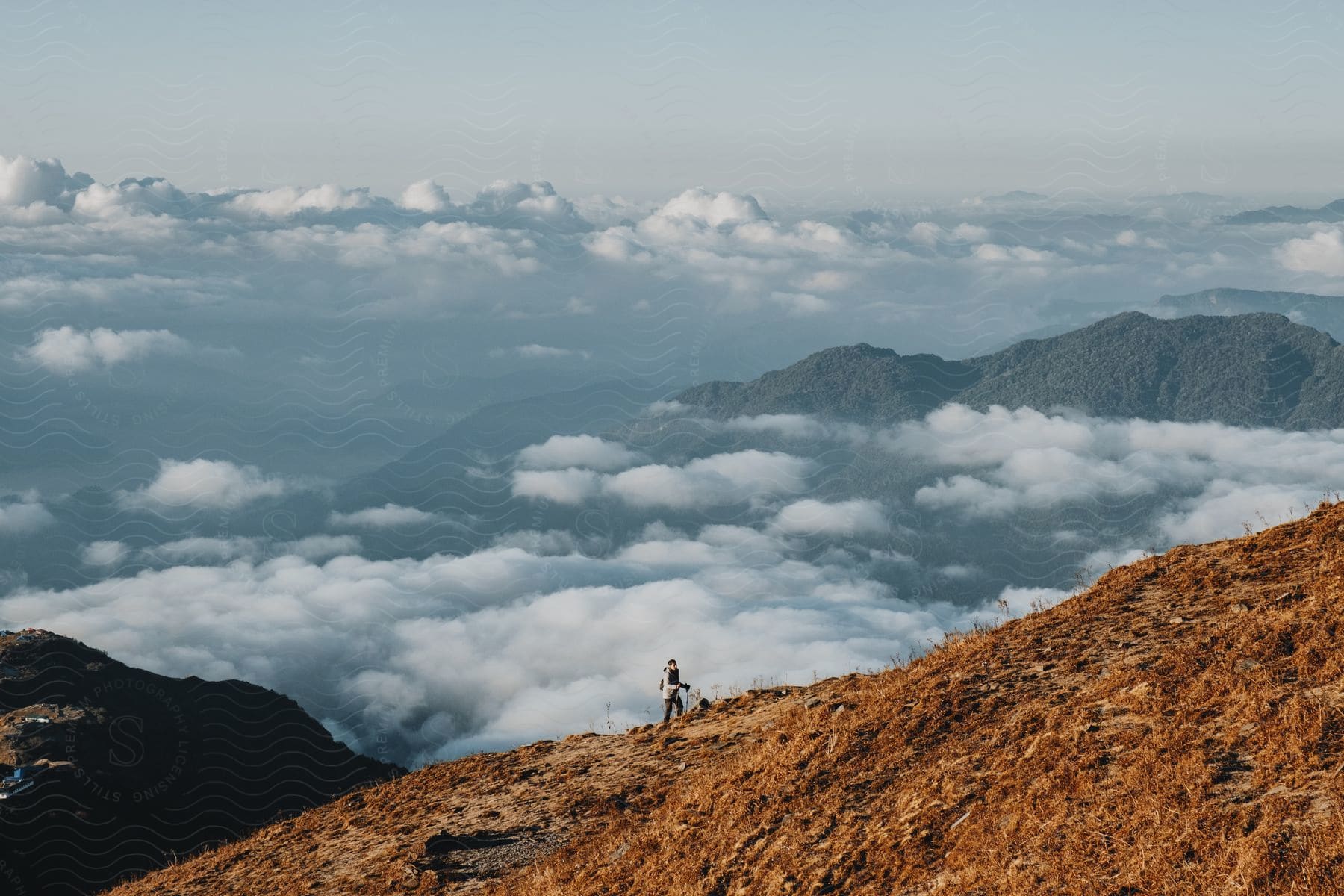 Mountainous landscape above cloud level with a person hiking