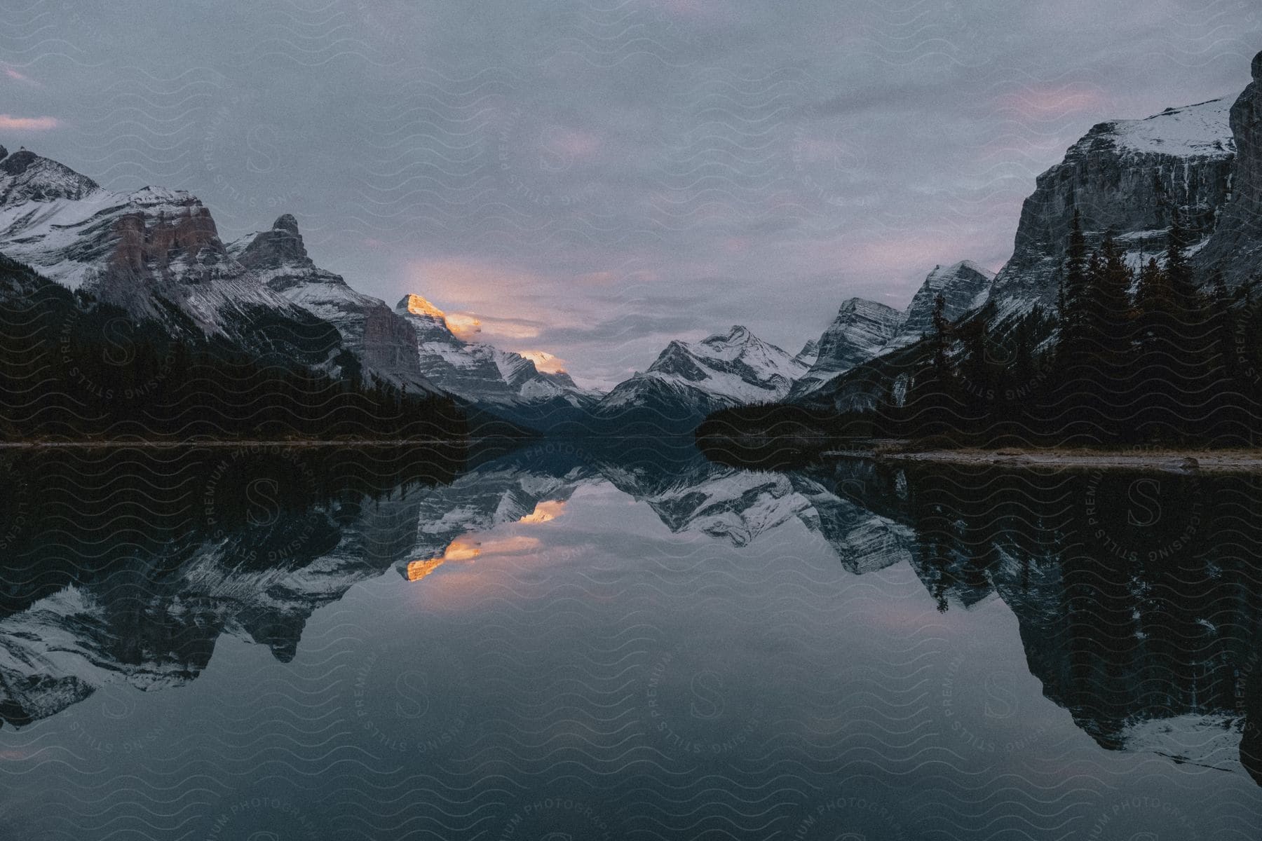 The still waters of the lake reflect the majestic, snow-capped peaks that surround it.