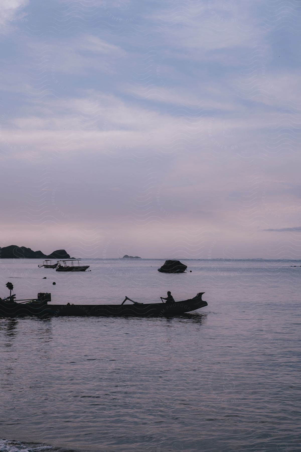 Some boats moving around out on water as viewed from the shore