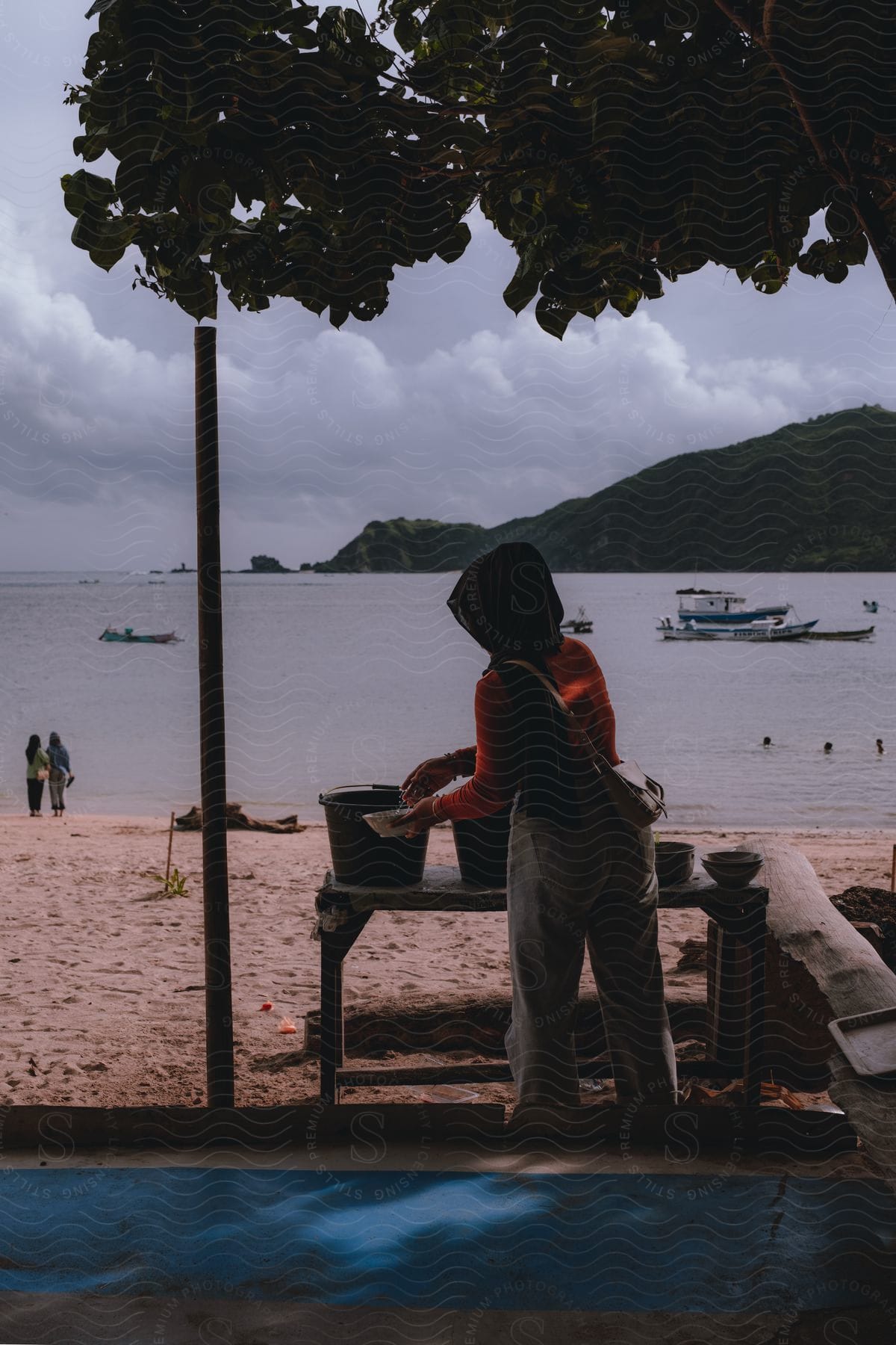 person is on the beach and standing next to four buckets