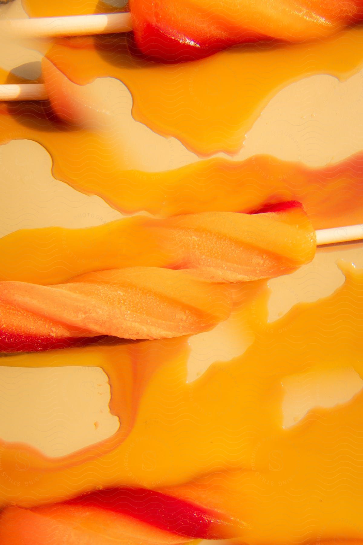 Orange popsicles lying down melting