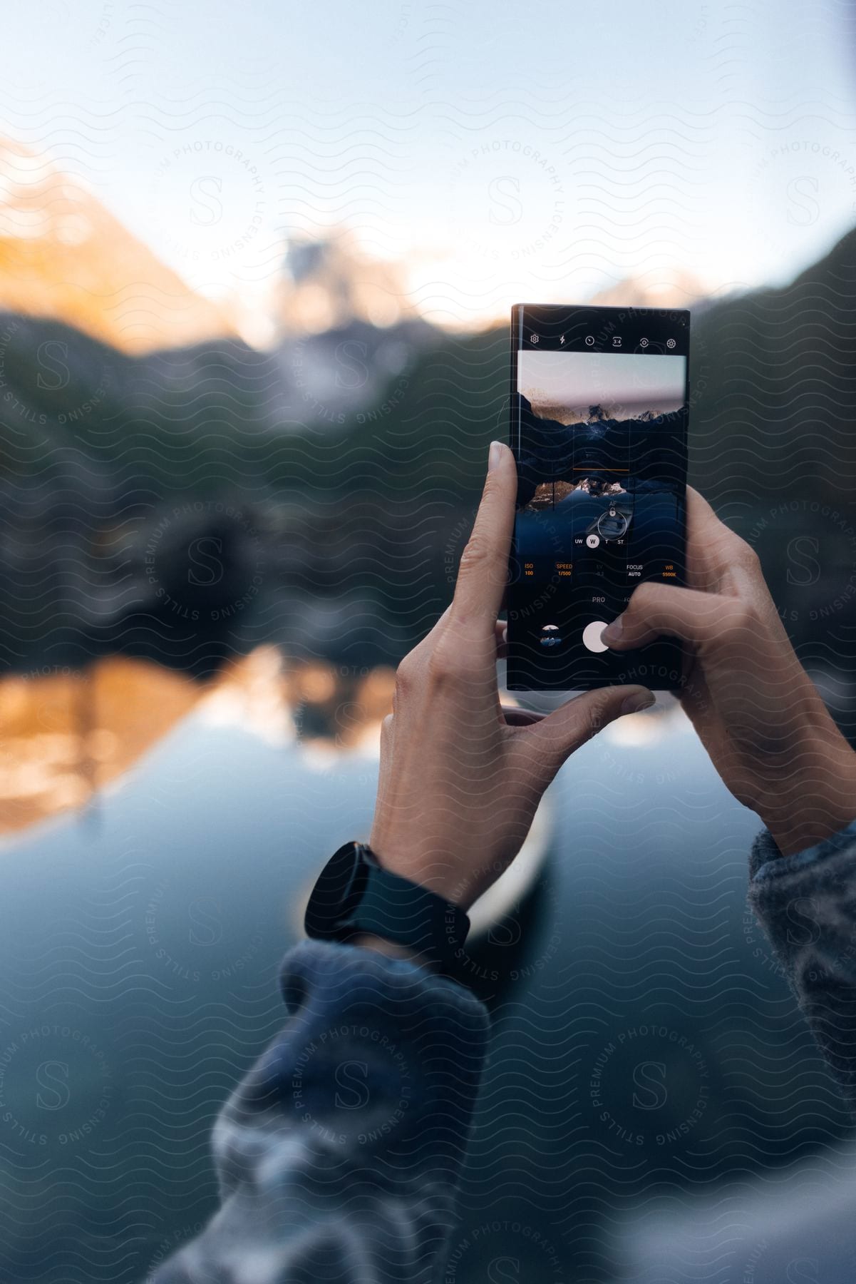 Stock photo of a person using a smartphone outdoors on a sunny day