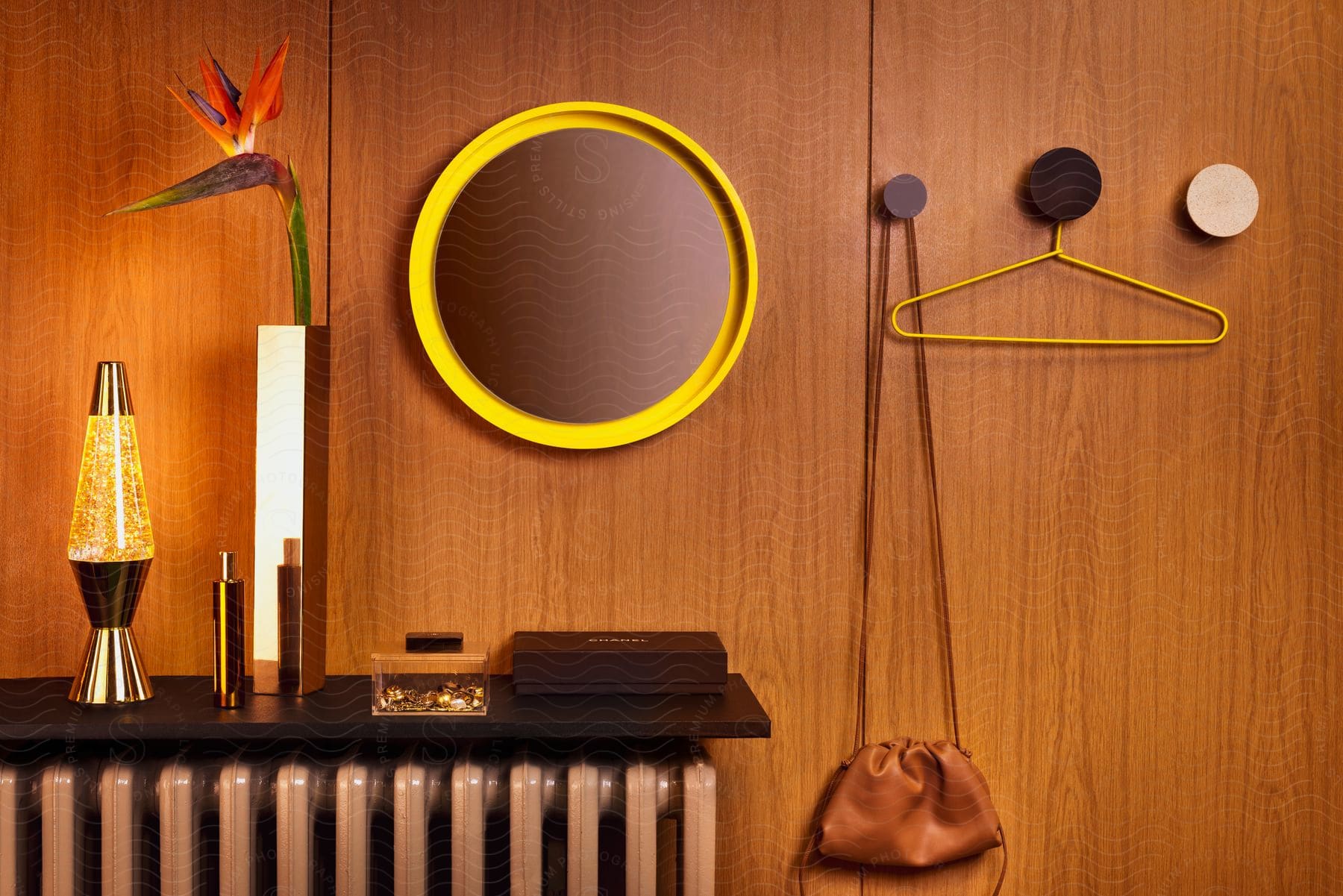 Wooden wall with decorative objects, including circular mirror, lamp and plant.