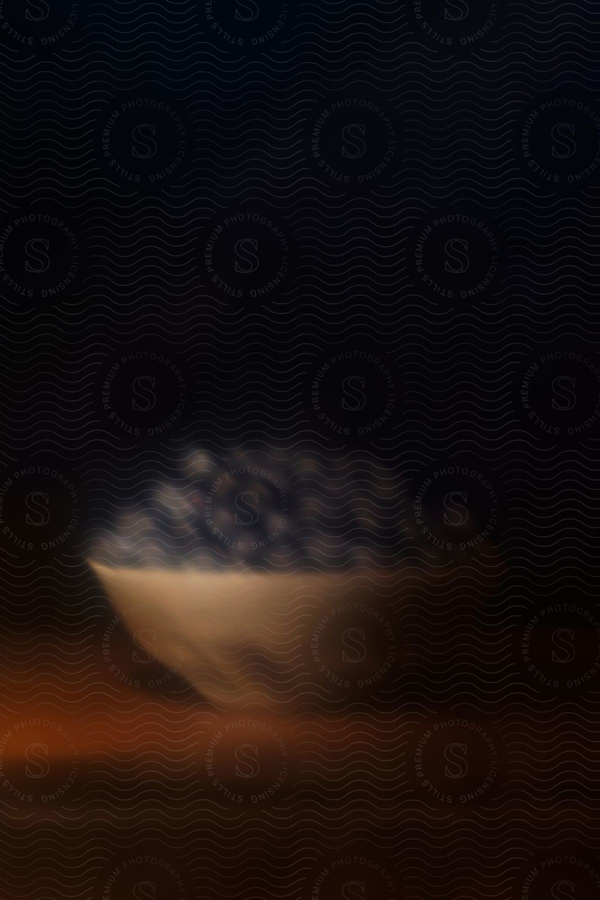 A bowl of blueberries sits on a wooden table.