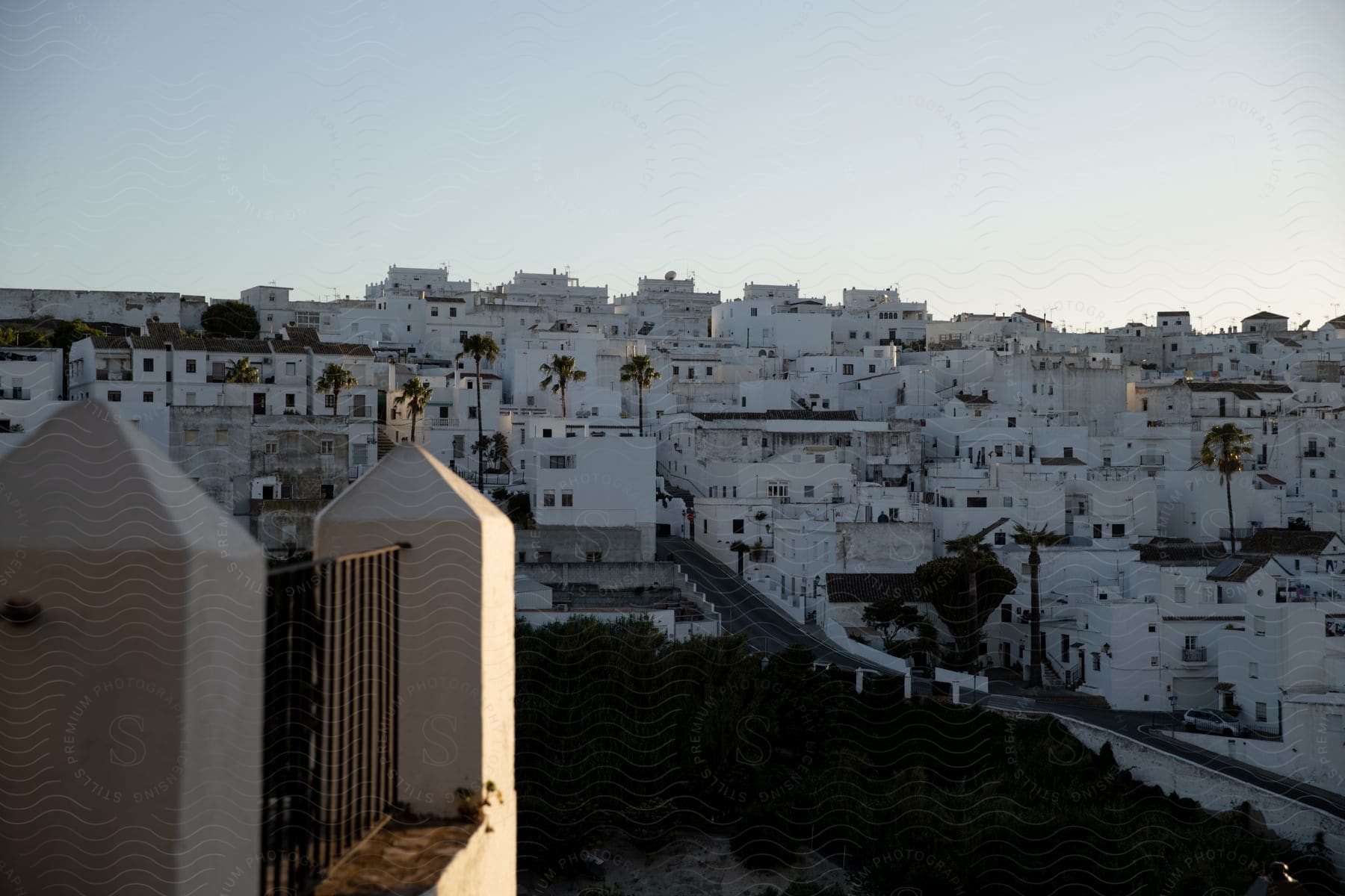 Stock photo of a view of a hill with a dense cluster of white buildings, possibly in the mediterranean architectural style.