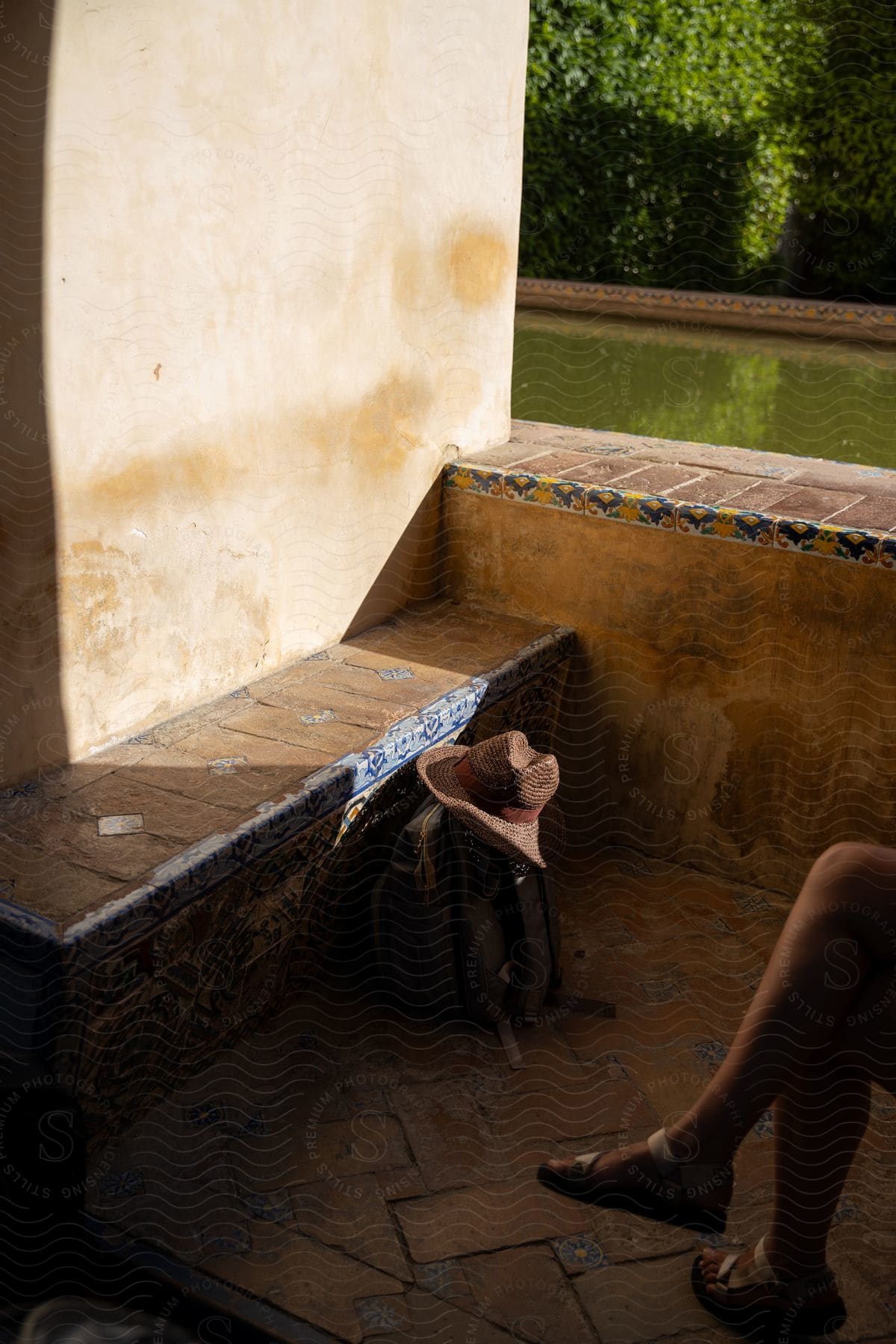 A person sitting outdoors on vacation near a backpack