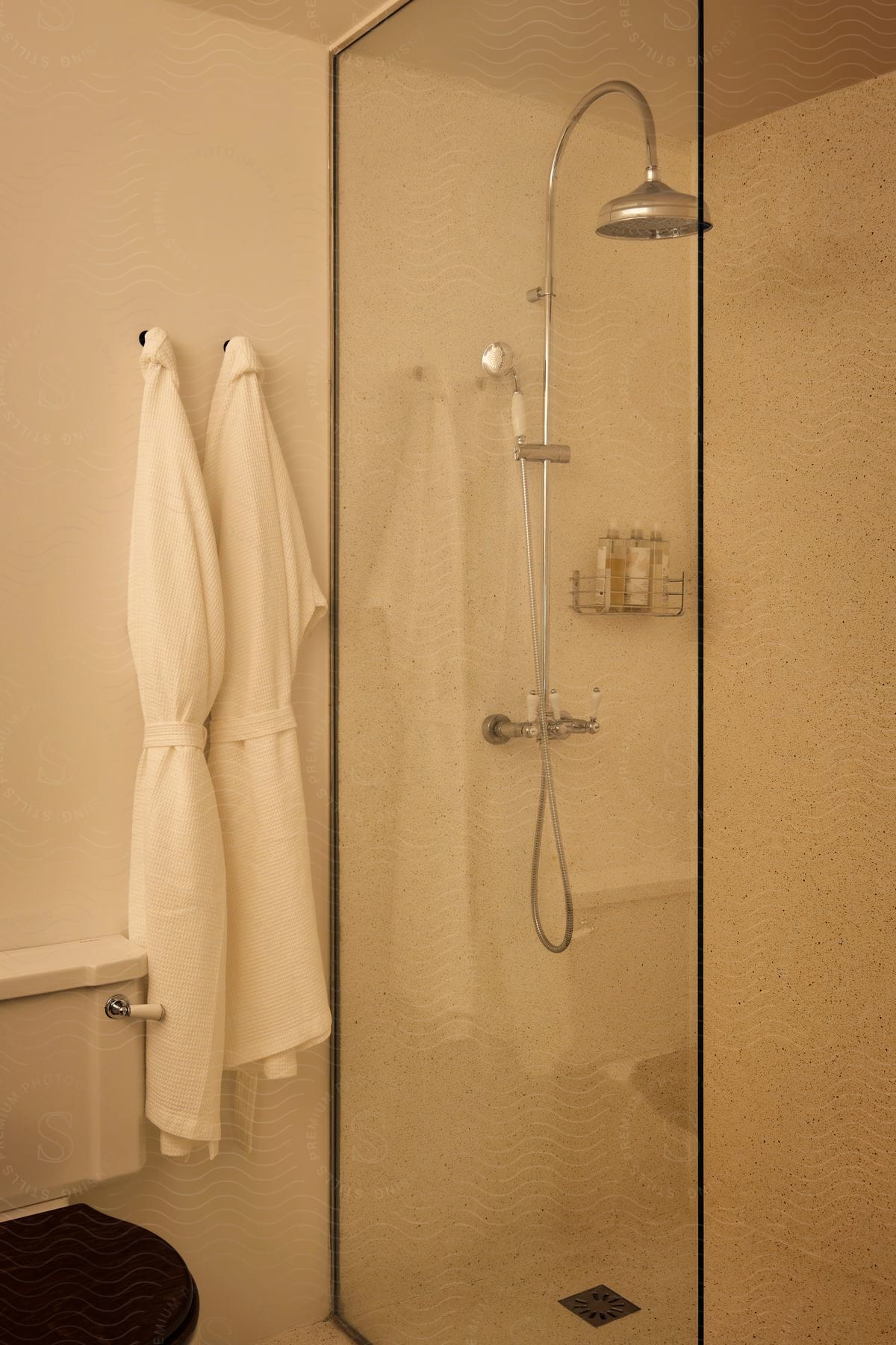 White robe hanging in the bathroom next to the shower