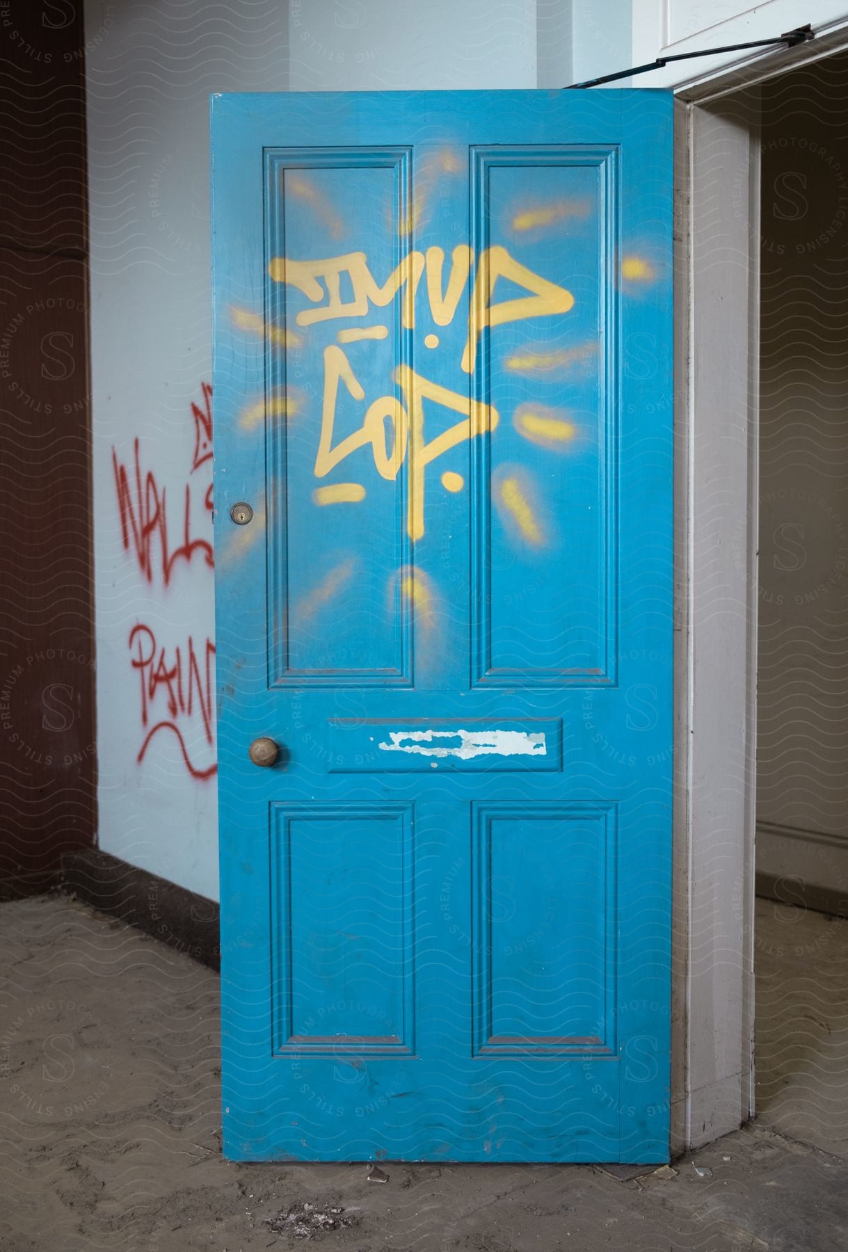 Graffiti spray painted on the door and wall of a vacant apartment