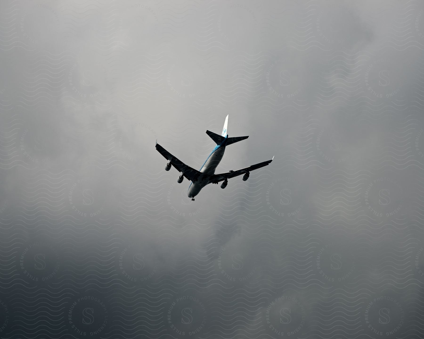 An airplane flying against an overcast sky