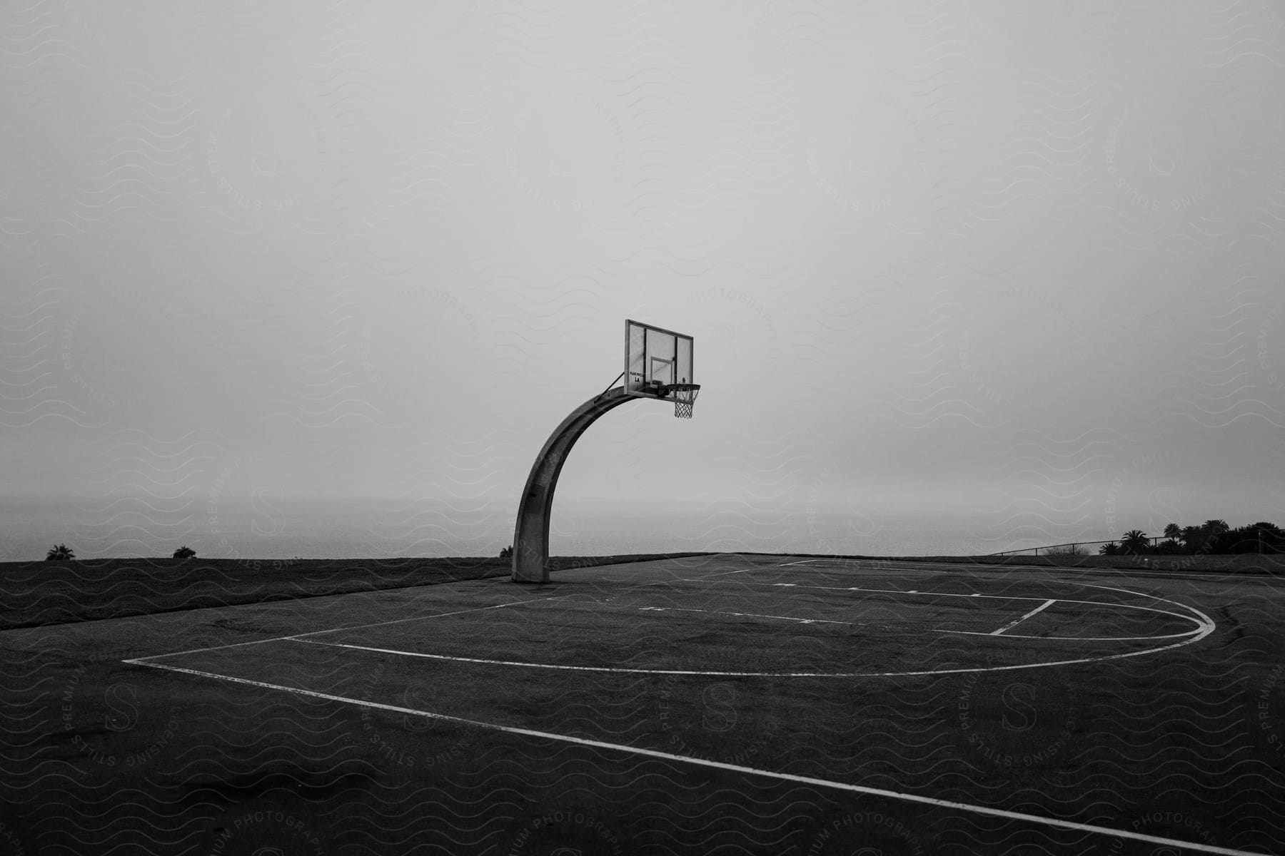 A basketball hoop hangs over an empty court along the coast