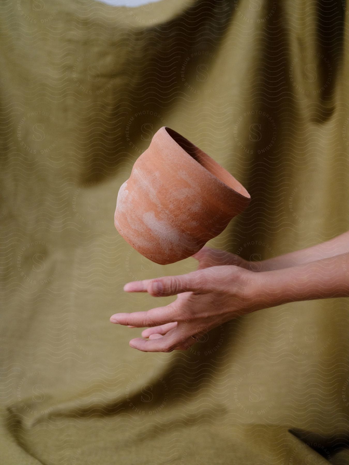 Hand reaches out to catch a cup suspended in midair