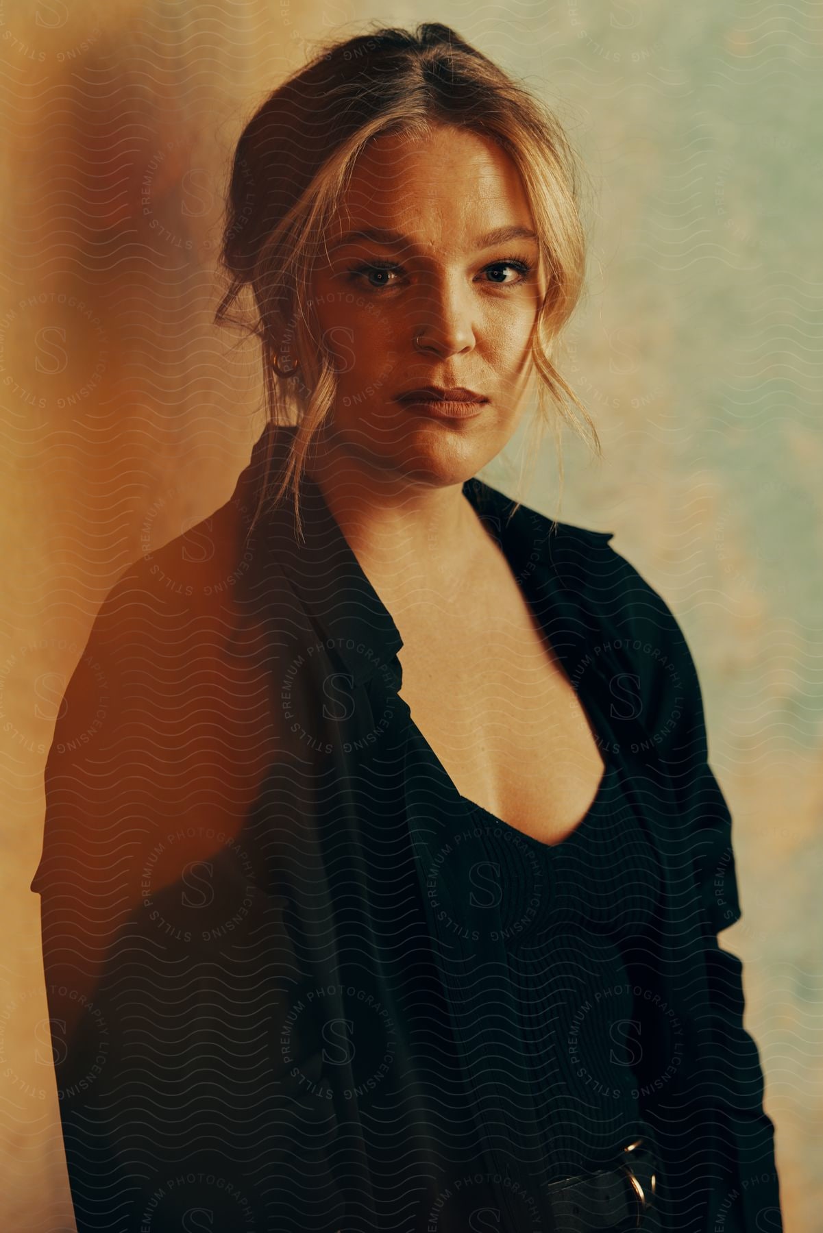 Blonde woman posing in front of a wall indoors