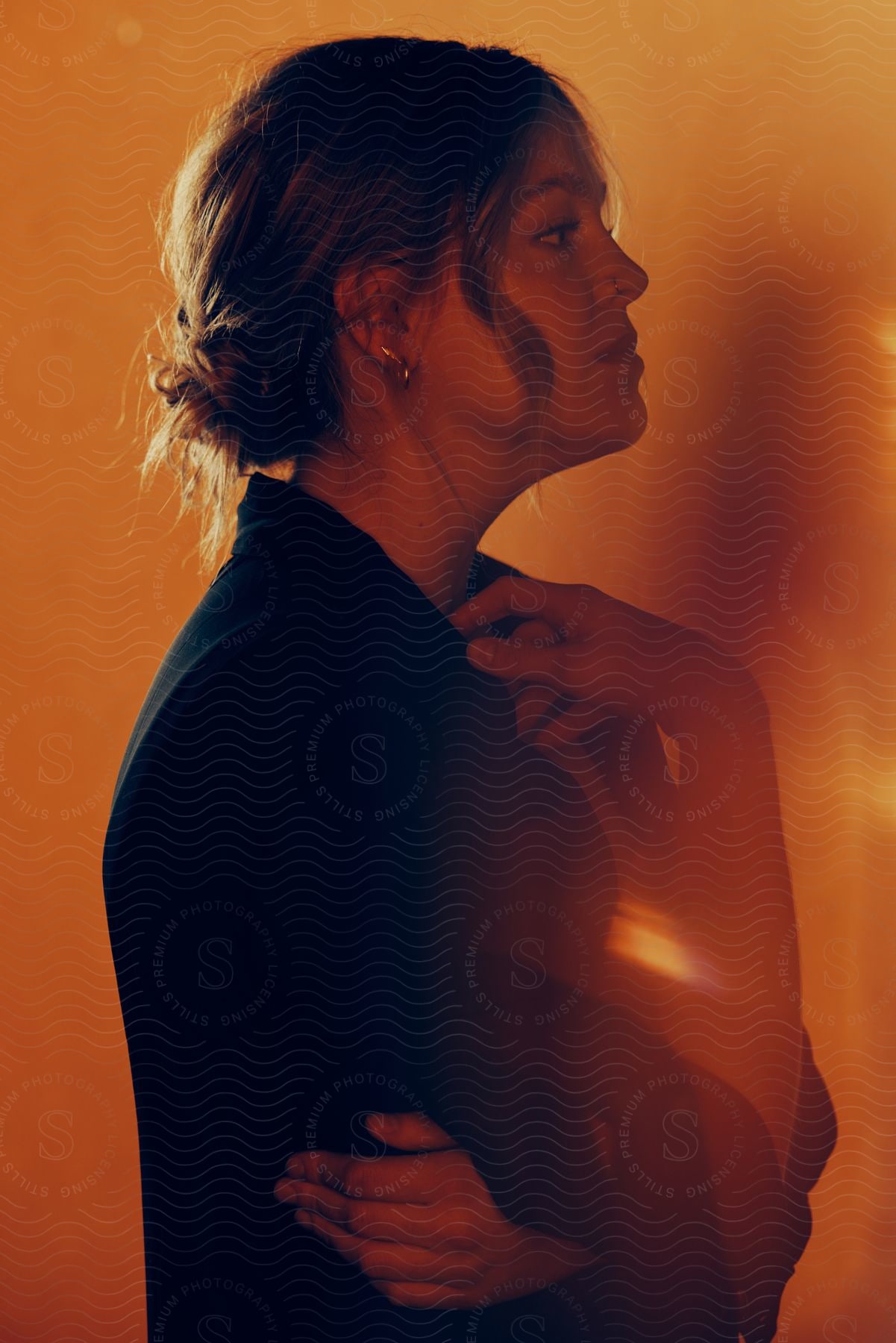 Woman in profile against a warm colored background