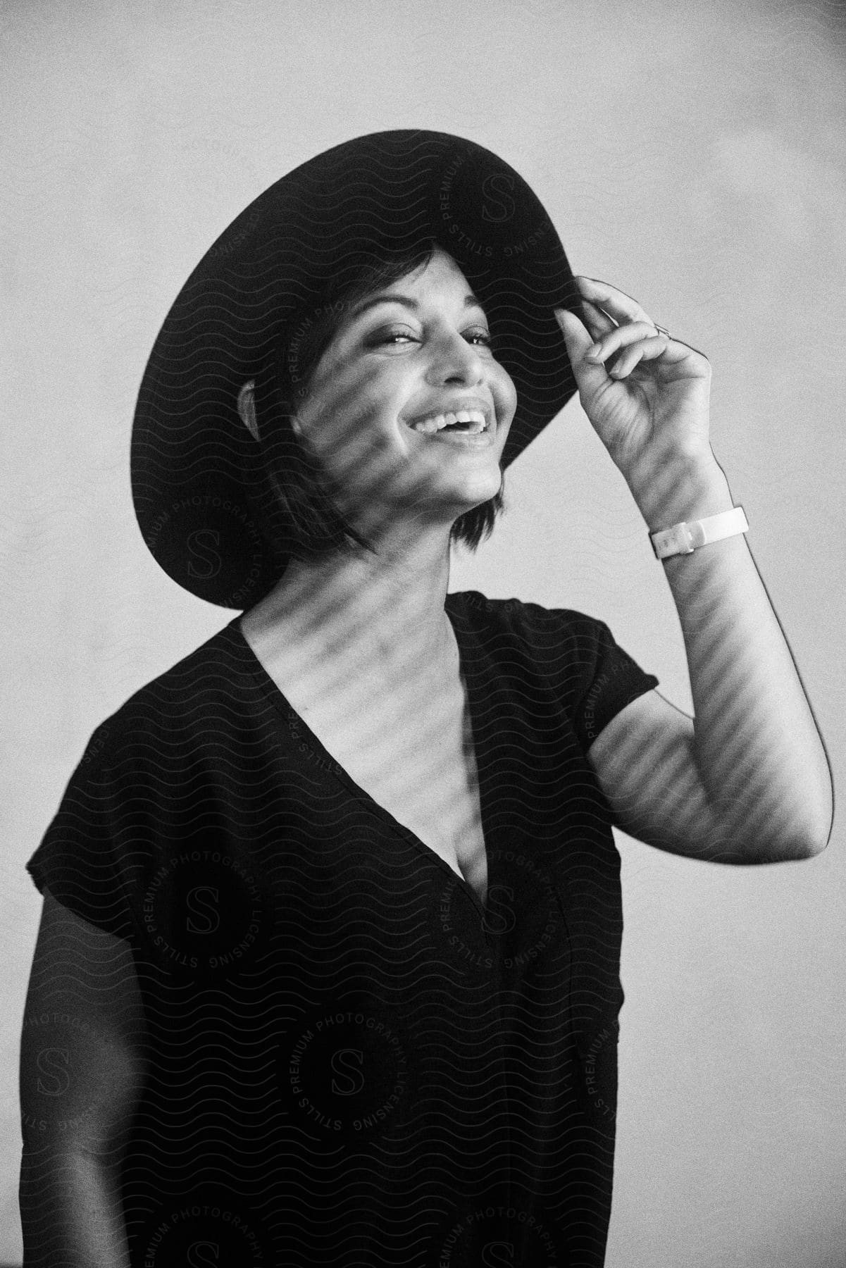 Woman wearing a black tshirt and hat touching her wristwatch