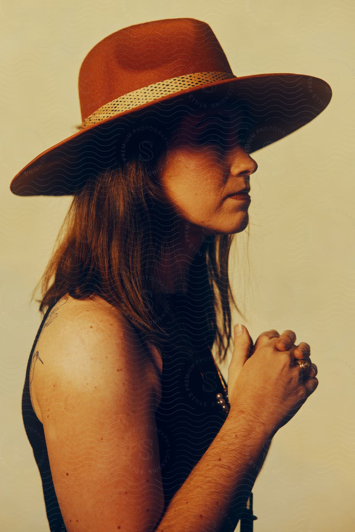 A woman wearing a wide hat poses for the camera