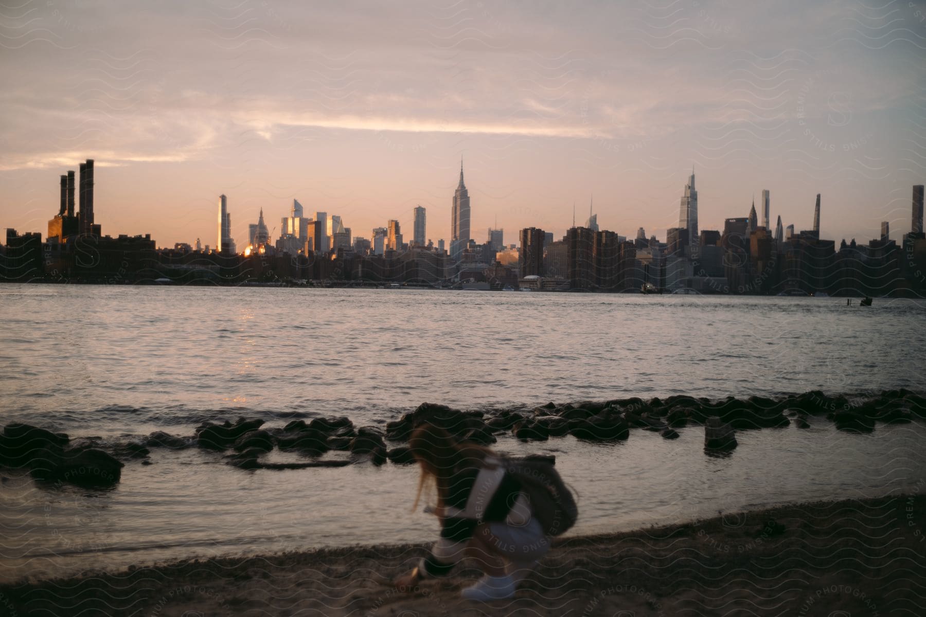 A serene urban landscape with a lake and skyscrapers at sunset