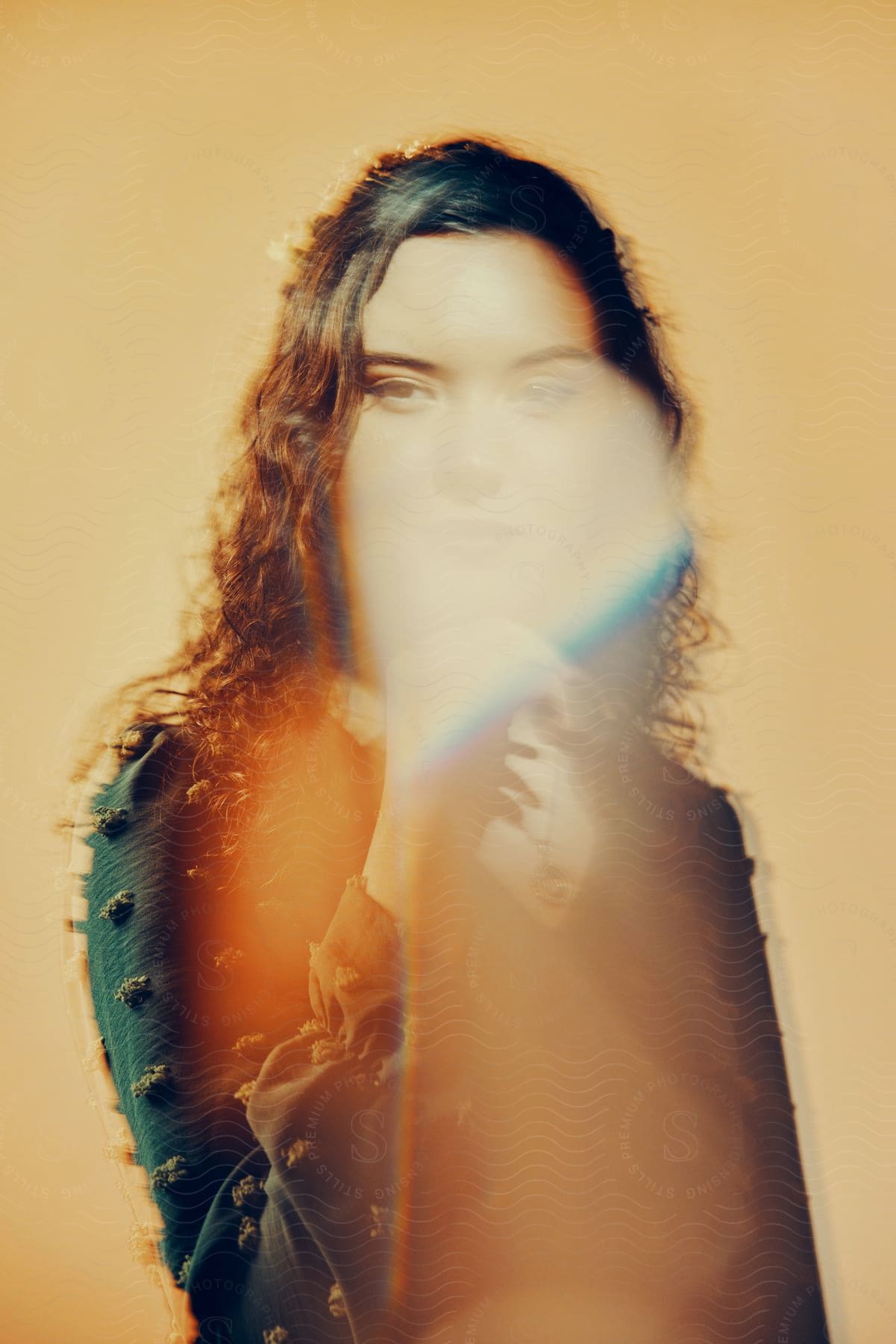 Black woman with long curly hair wearing a black jacket and necklace smiling