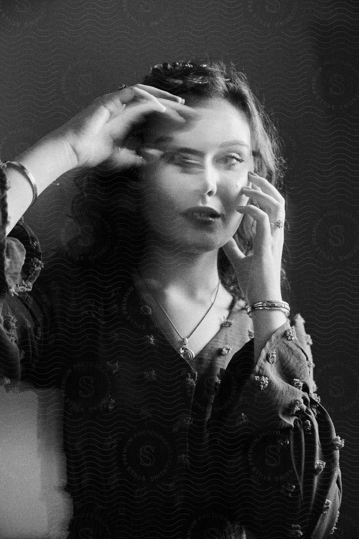 Woman posing with hands to create double exposure effect in black and white