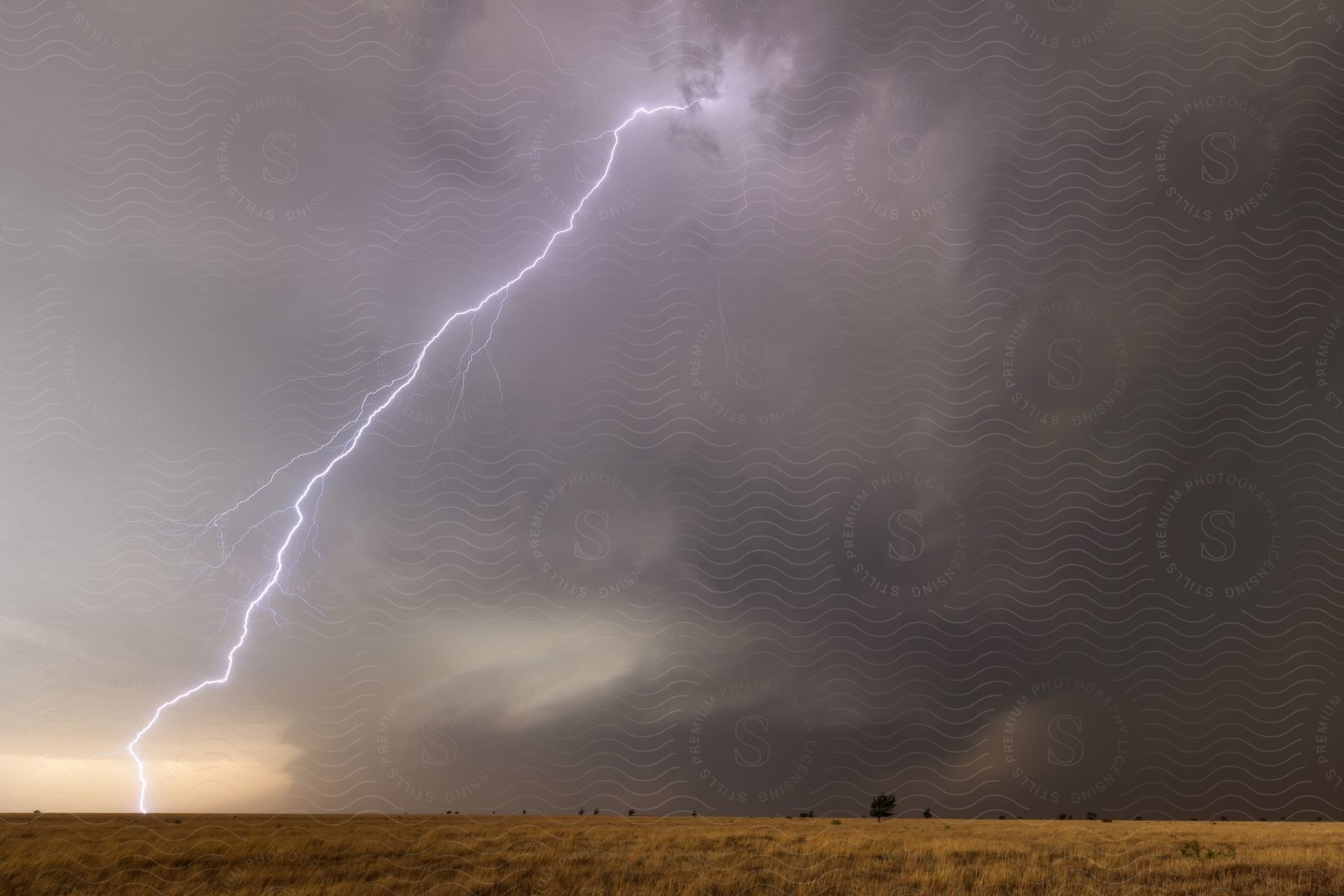 A lightning bolt striking over dry plains during a storm