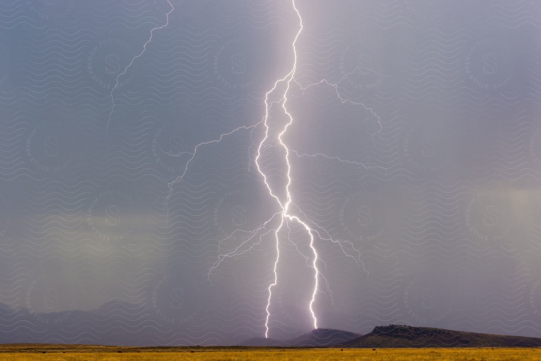 A thunderstorm strikes an open field in the desert southwest at night