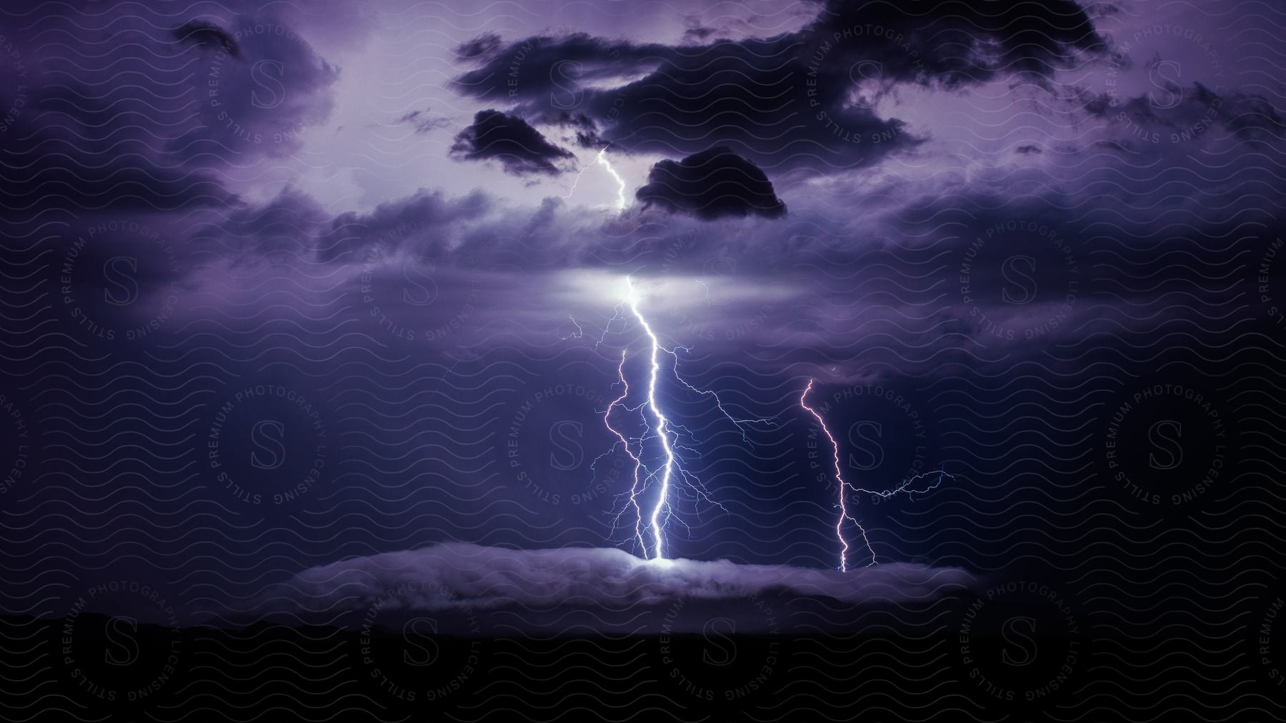 Lightning Illuminates The Clouds Over The Land On A Stormy Night In Southern Arizona