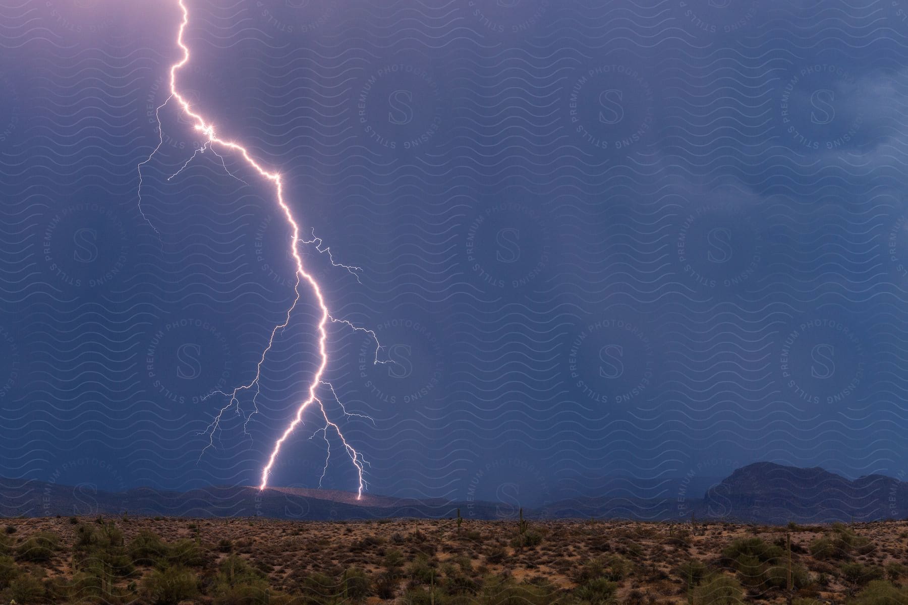 A desert landscape with lightning striking a mountain at night in the four peaks wilderness area northeast of phoenix
