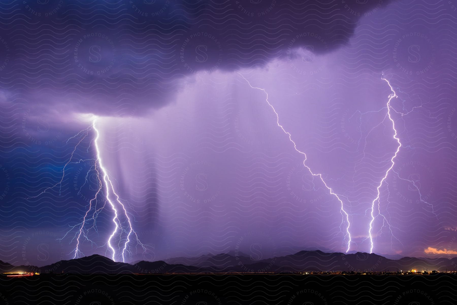 Purple lightning storm with mountains in the background