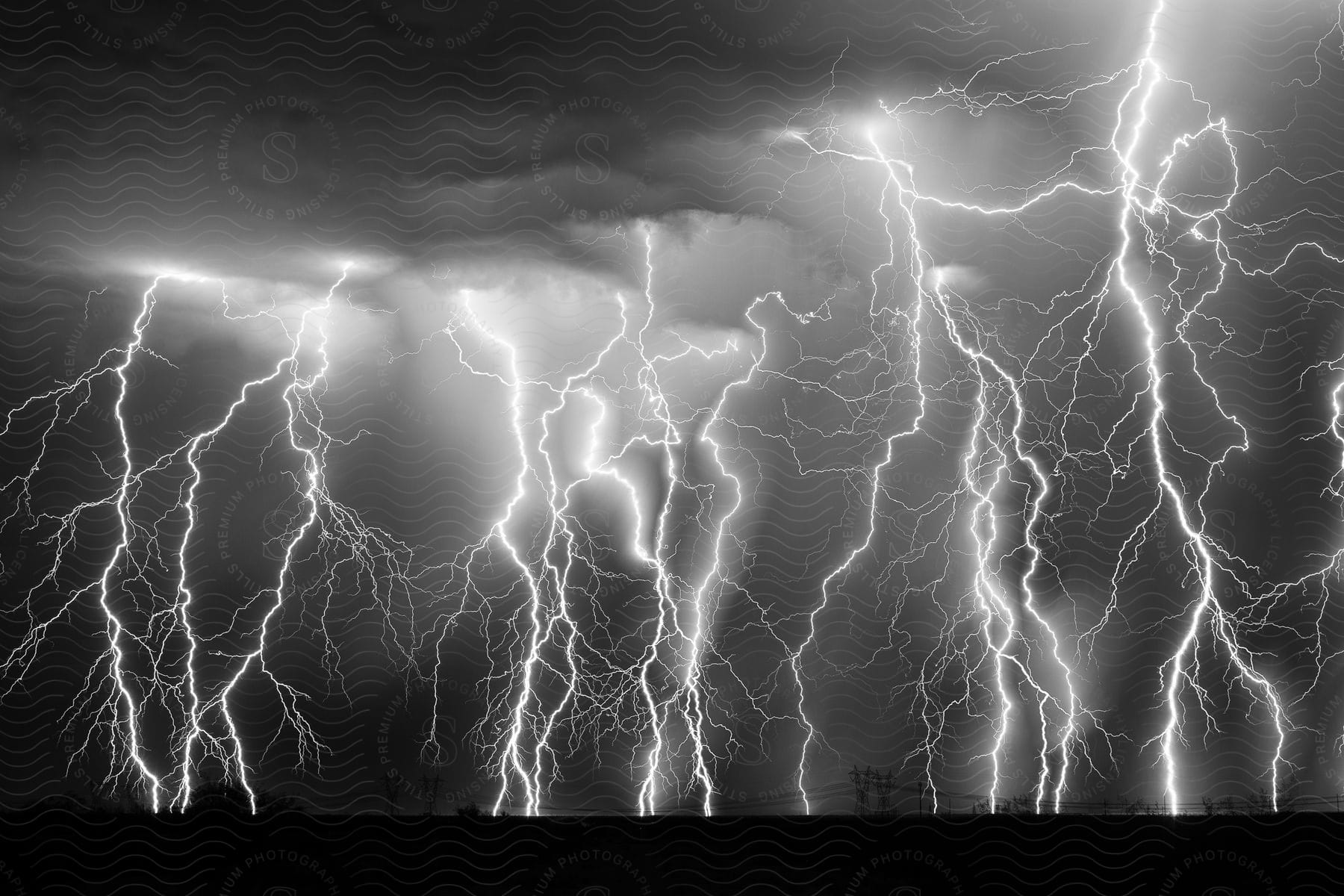 Stock photo of multiple exposure black and white shot of lightning strikes on the countryside