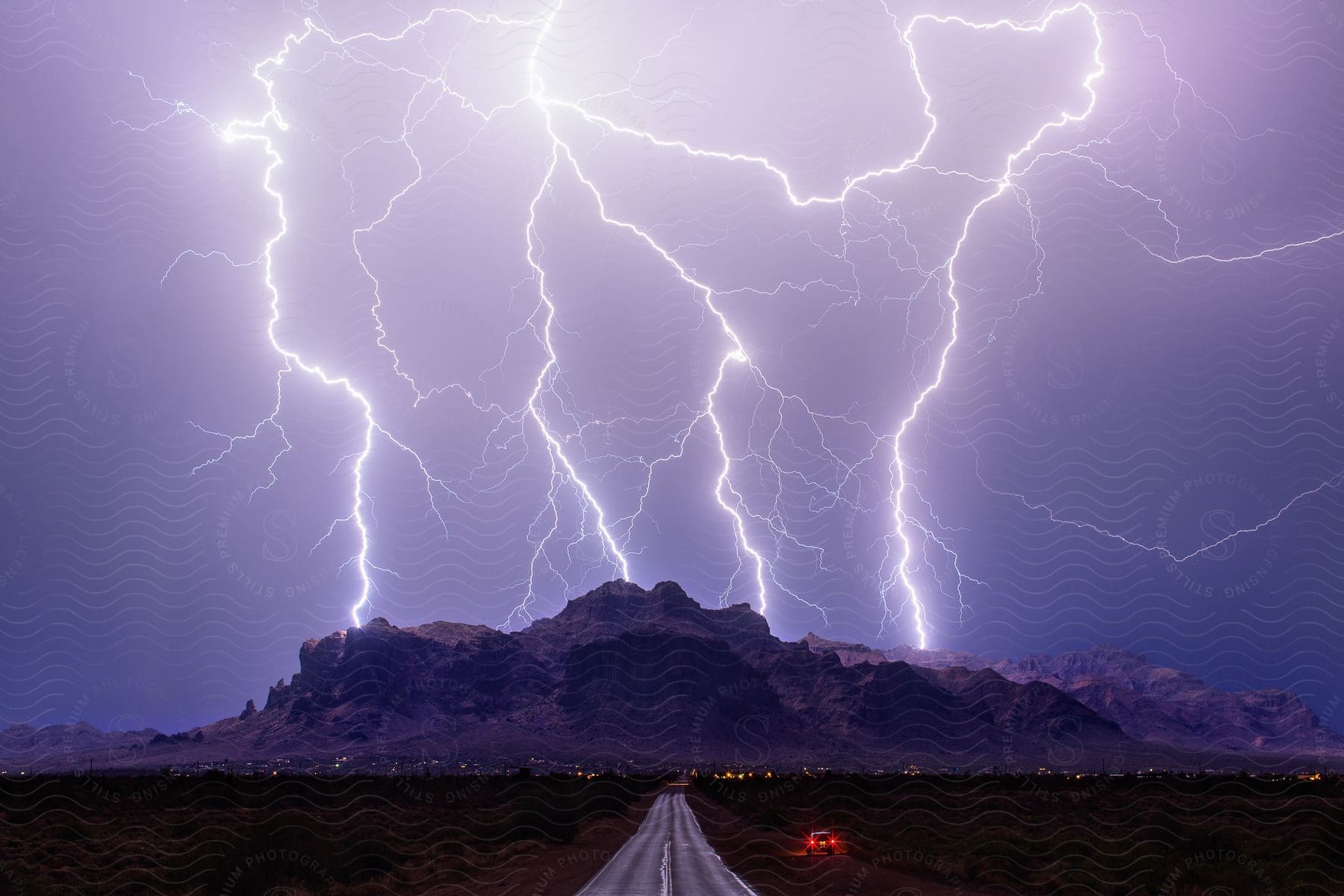 A thunderstorm falls on a mountain range above a desert town