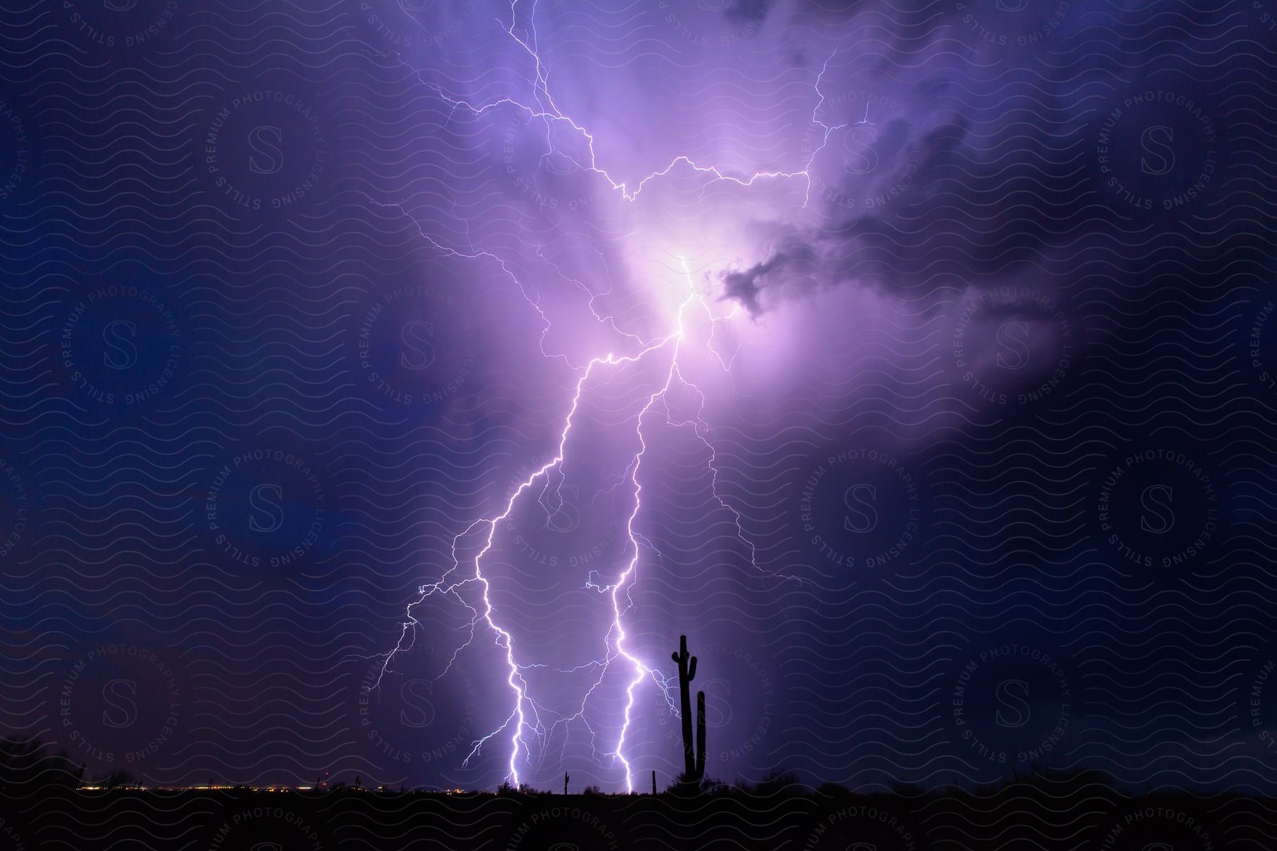 Lightning strikes illuminate the sky above whittman az during a thunderstorm