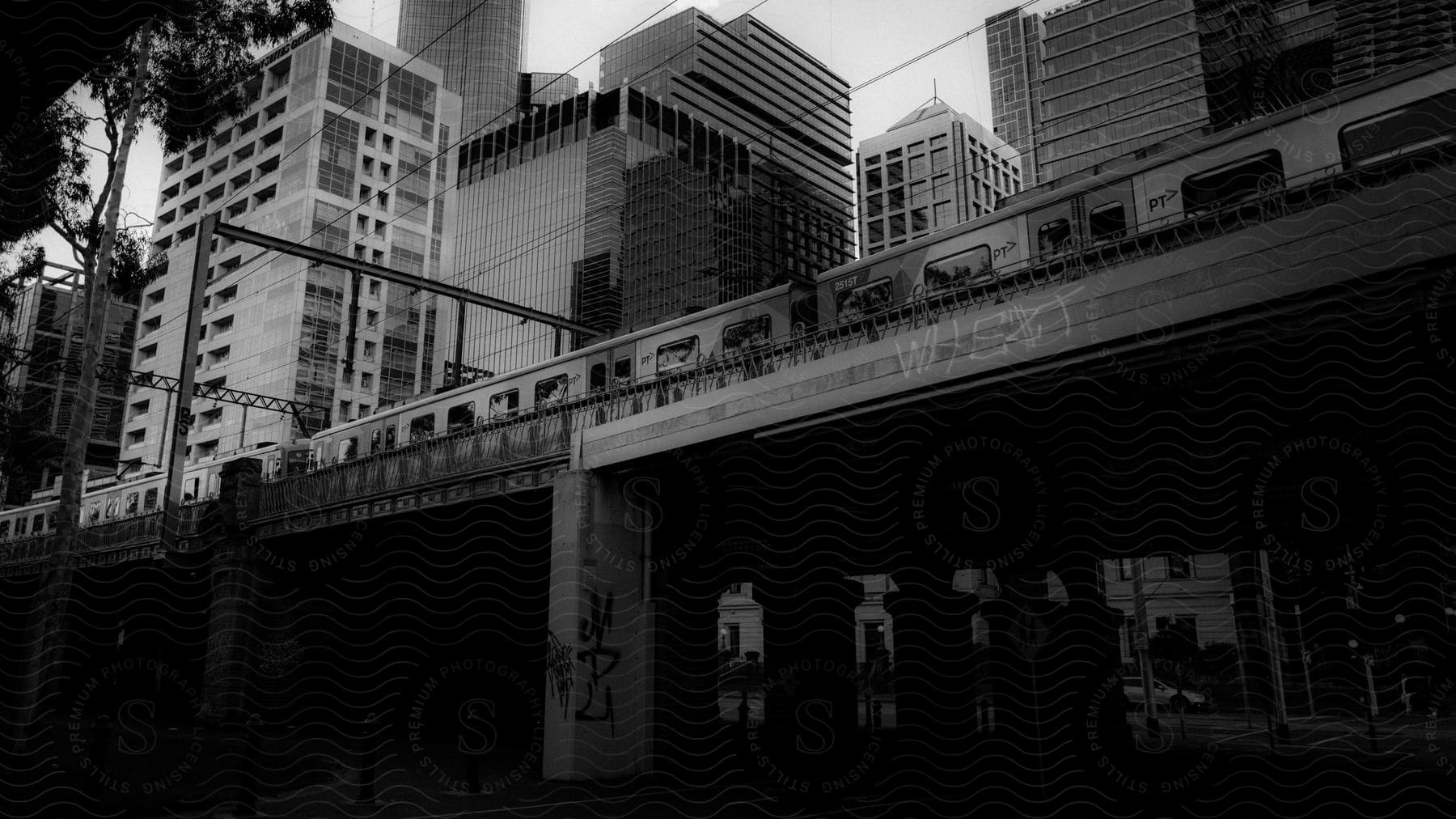 Train passing over a bridge with buildings in the background in an urban city