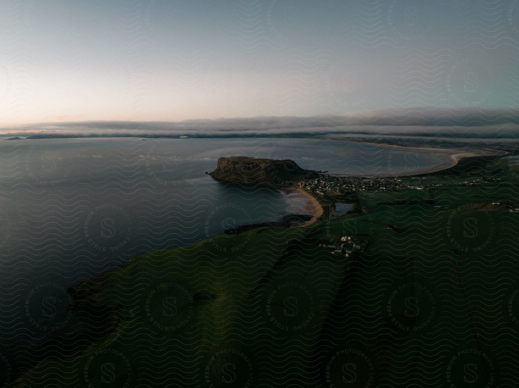 Clouds on the horizon can be seen in the dawning sun over a coastal town