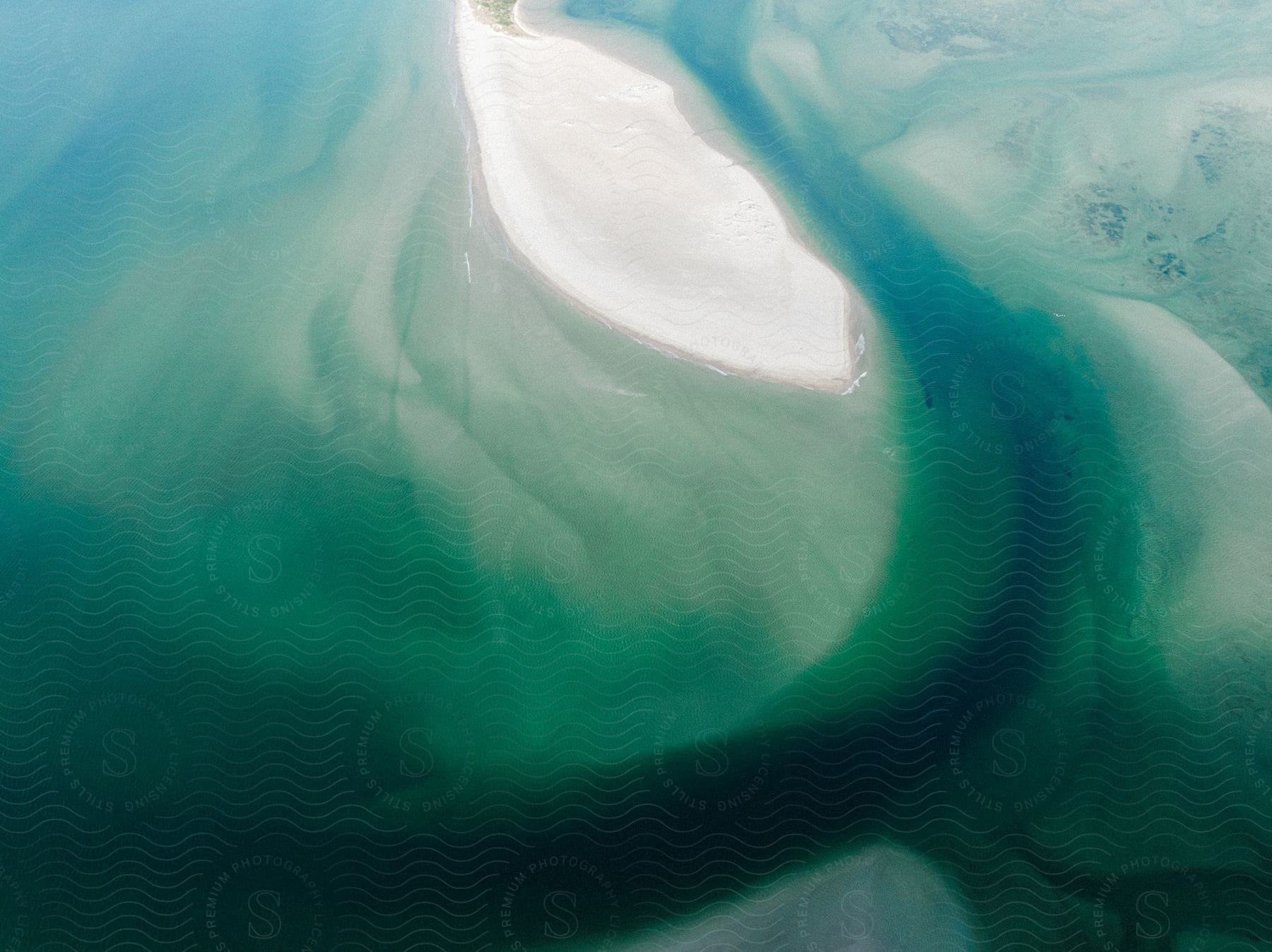 A sand dune surrounded by ocean seen from the air