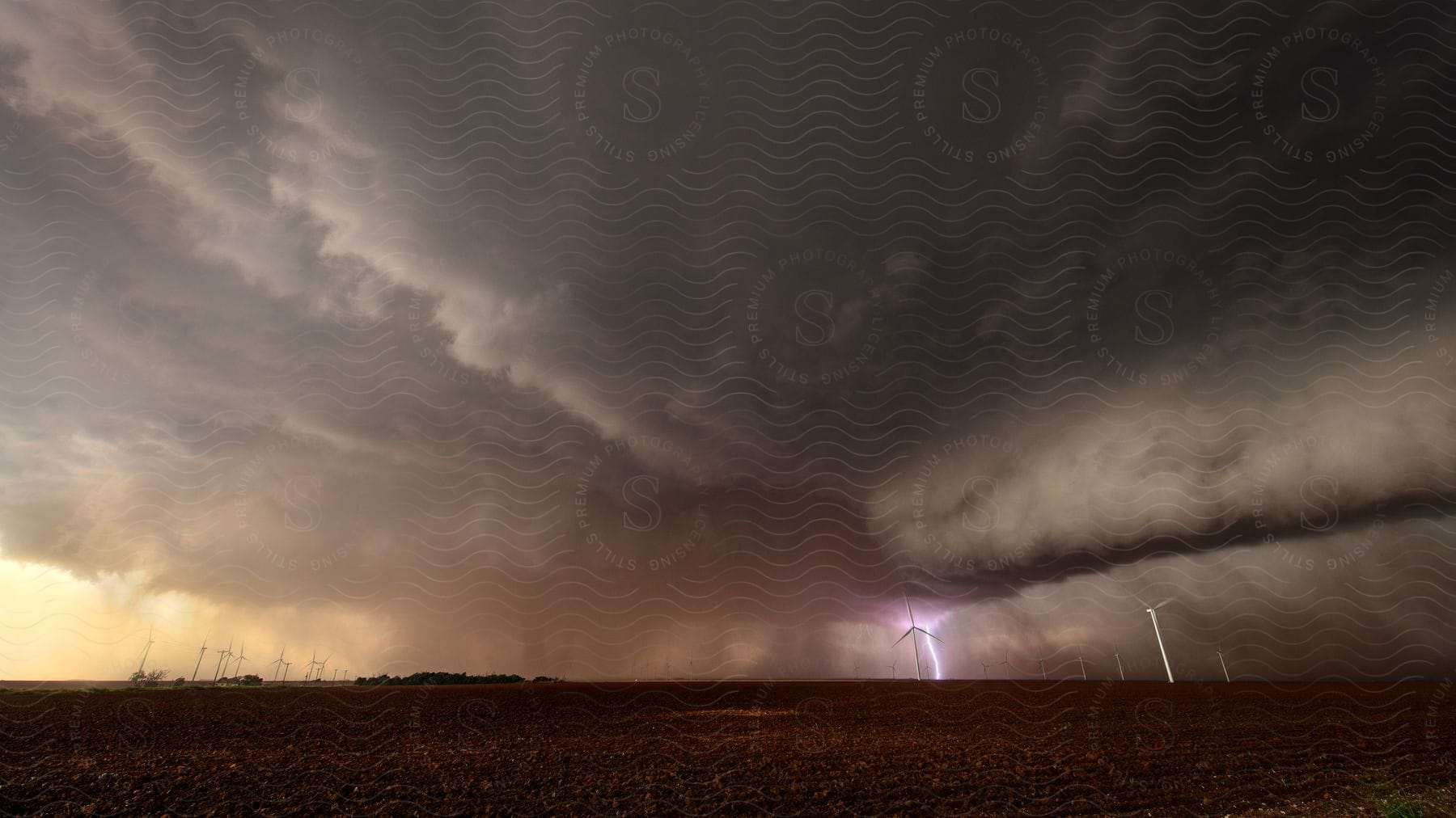 A thunderstorm looms over a cloudy day with a barely visible tornado in the rain near the town of tahoka tx